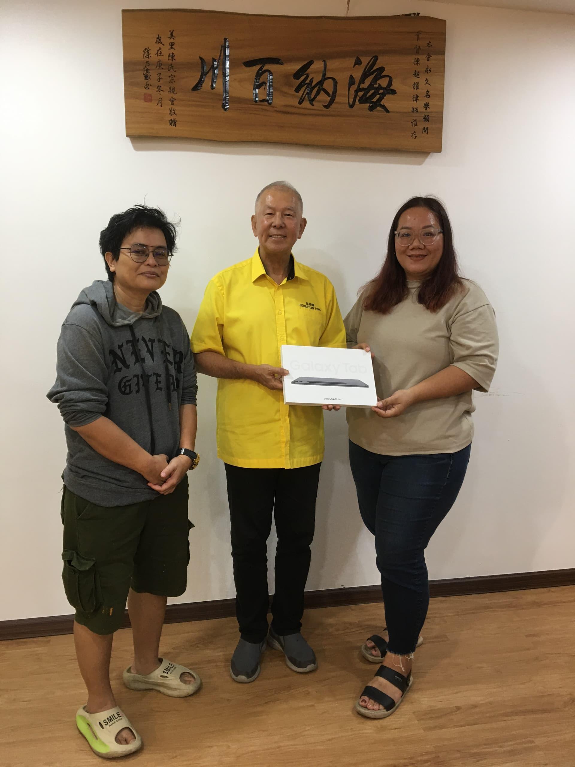拿督陈超耀赞助一台平板电脑予北砂新协做为该会圣诞晚会幸运抽奖。左1為筹备会主席珍妮花从拿督陈超耀手中接过赞助奖品。