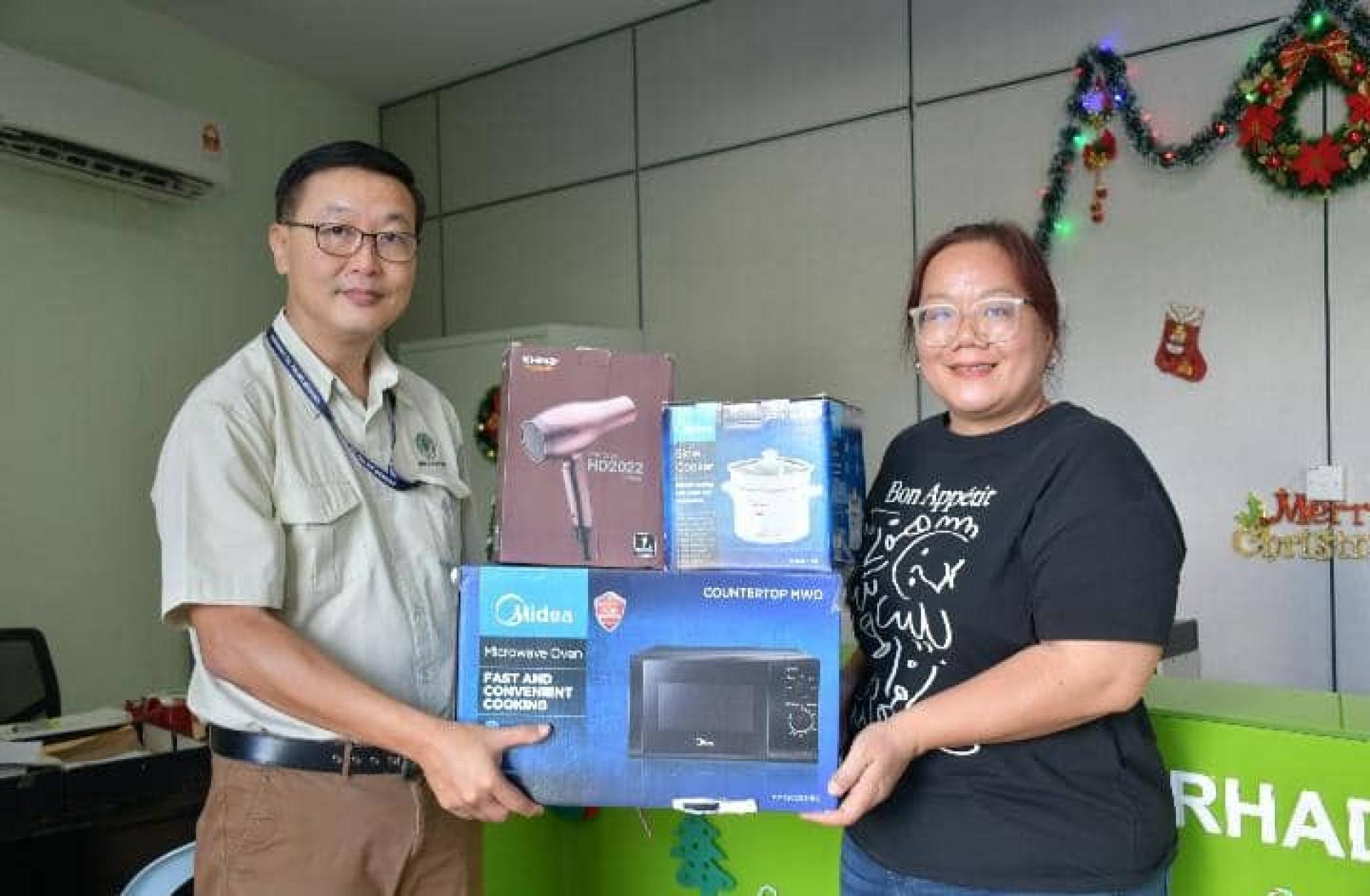 砂油棕集团行政部高级经理刘利豪（左）移交赞助品予筹备会主席珍妮花。