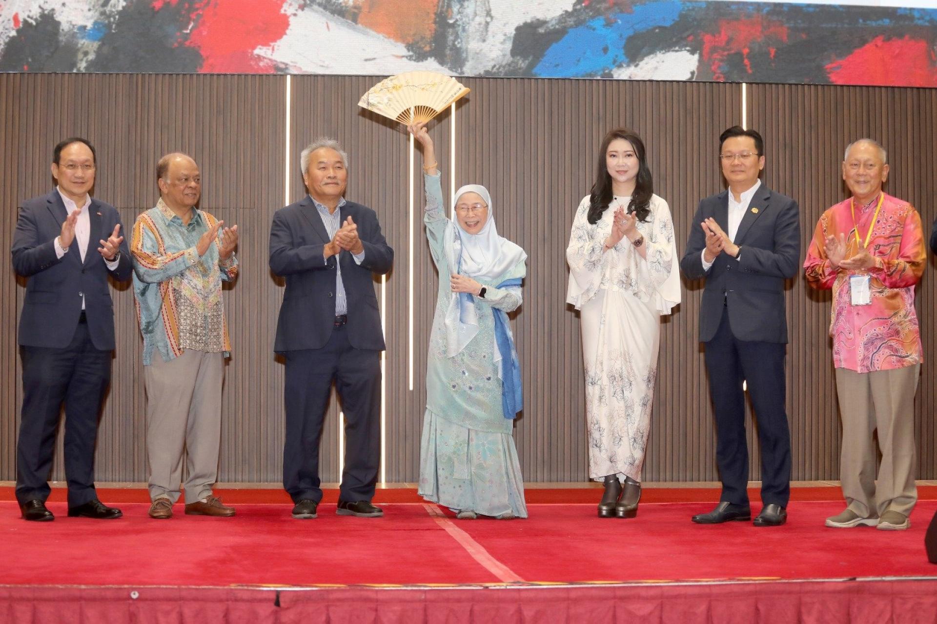 旺阿兹莎（中）为“东盟–中国艺术交流画展”主持开幕礼后获主办单位赠送一把名为“梅竹相伴好时光”为题的扇子。