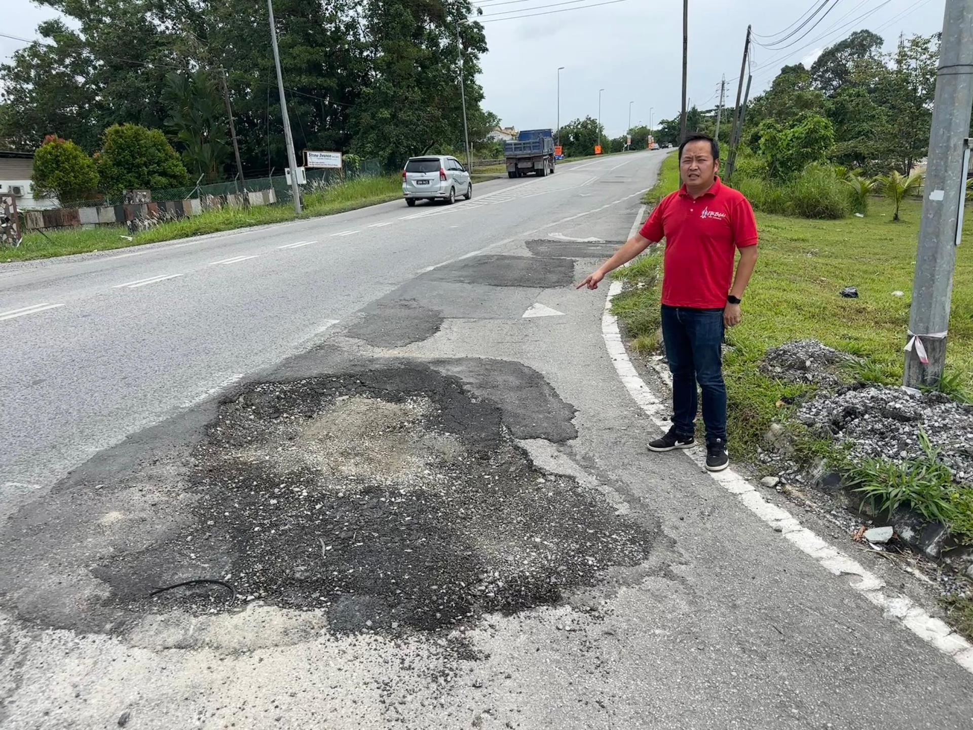 江峰年指着不堪的路面状况，促当局派员维修。