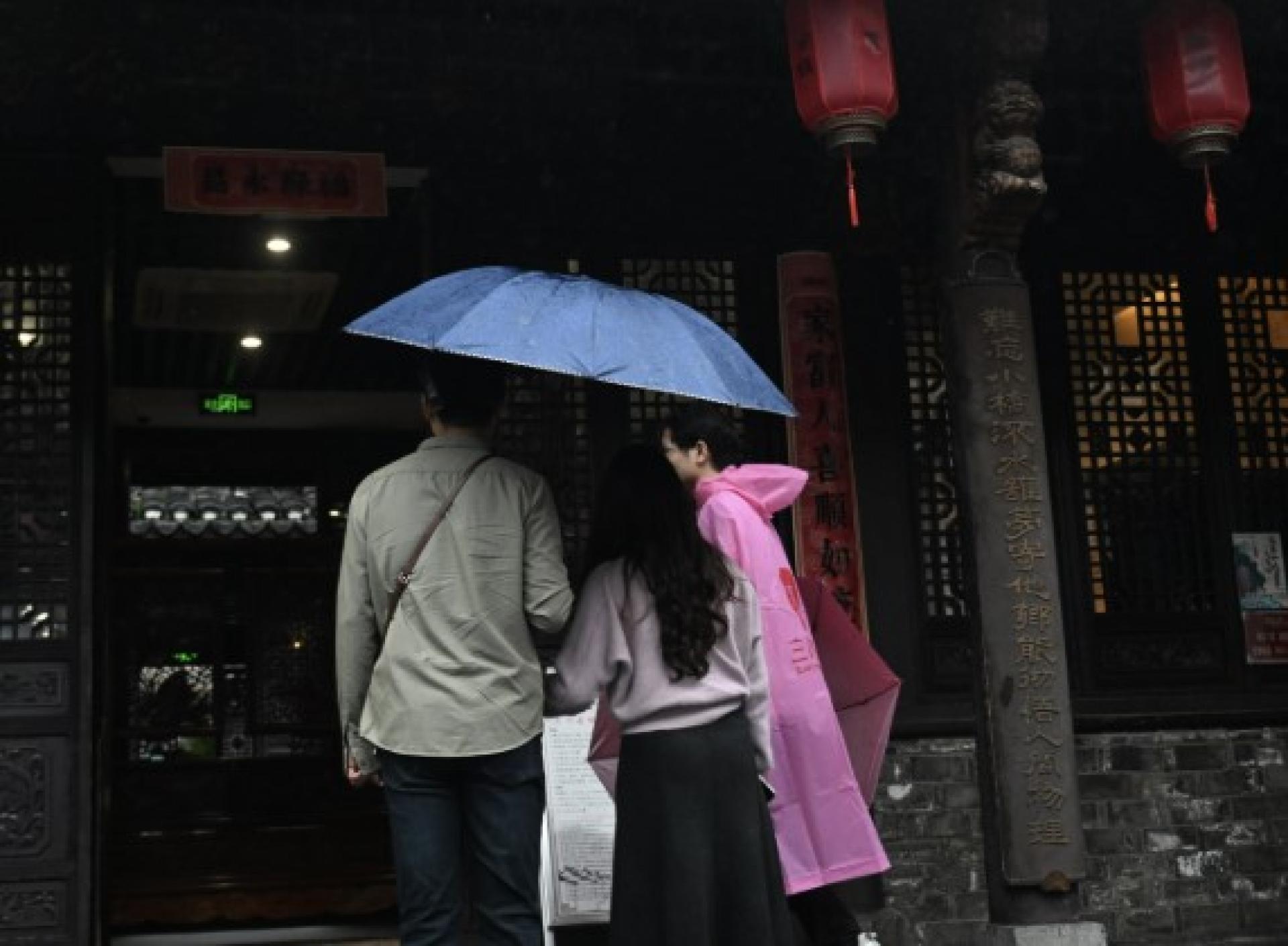 民众18日在雨中走进杨振宁旧居参观缅怀。