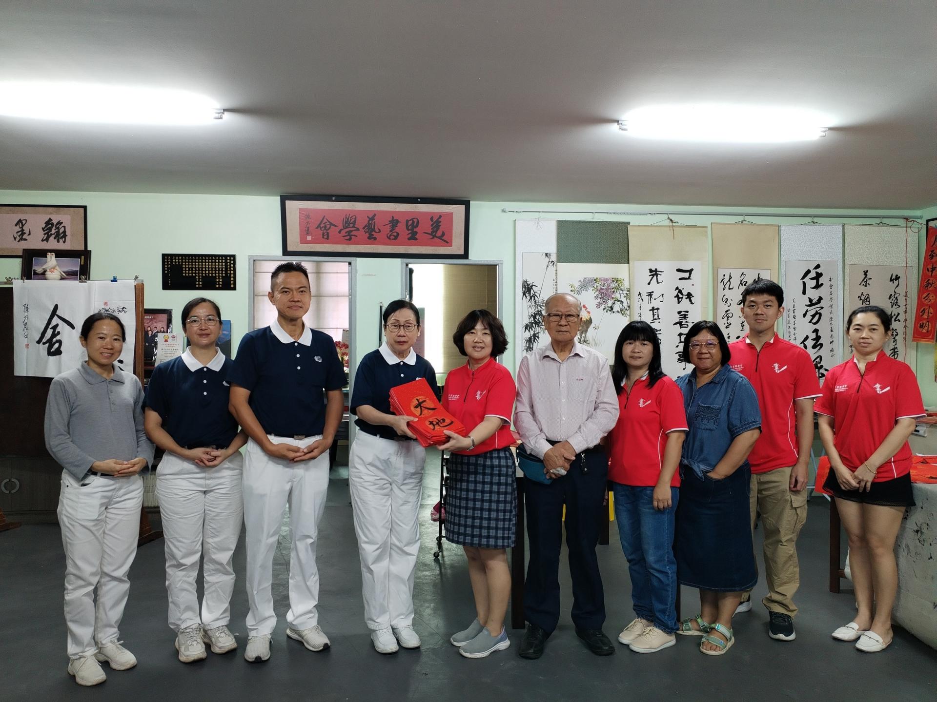 美里书艺学会的会长甘美美（左5）将春联移交给美里慈济志工潘艳玉（左4）。右5为美里书艺学会美里书艺学会名誉会长陈乃豪。