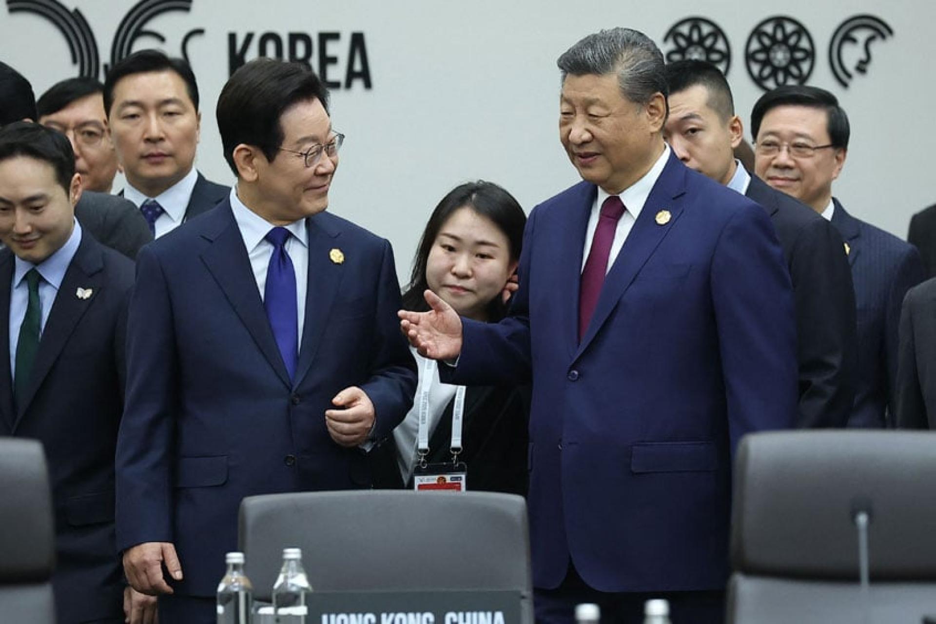 中国国家主席习近平（右三）与韩国总统李在明（左四）在峰会期间交谈。