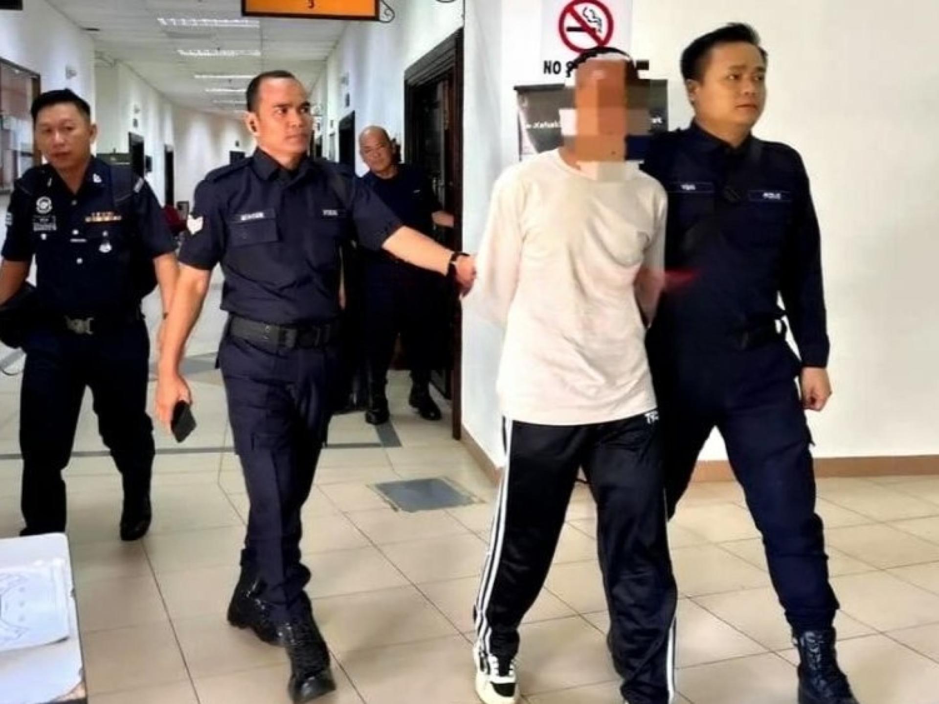 身穿白衣的被告在警员押送下离开地庭三庭。