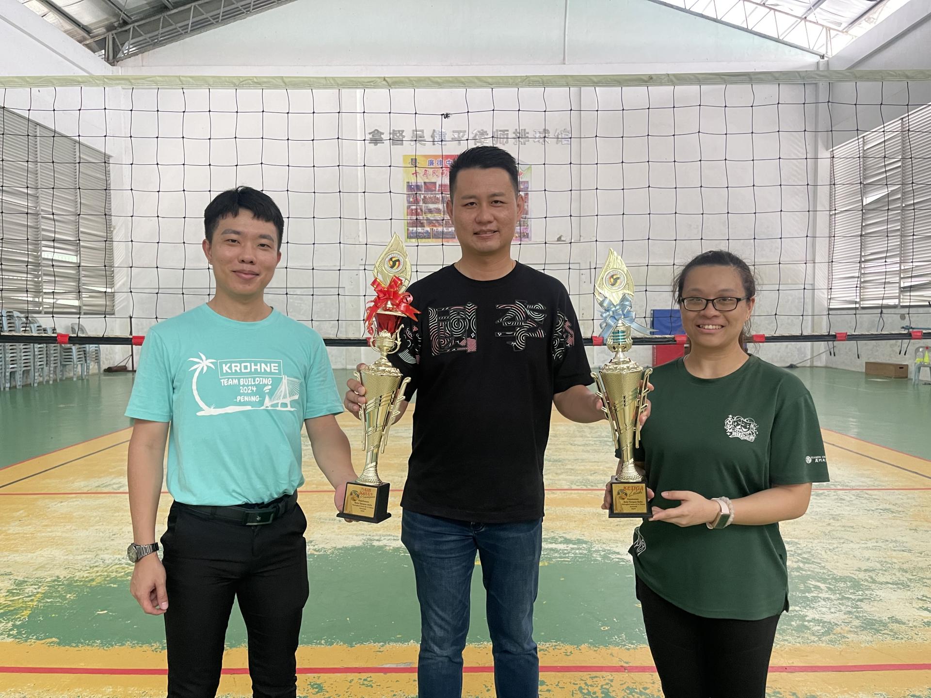 美里排球总会会长林思健律师（中）从主席温凯富贵（左）和女队副教练黄舒扬（右）手中接过奖杯时摄。