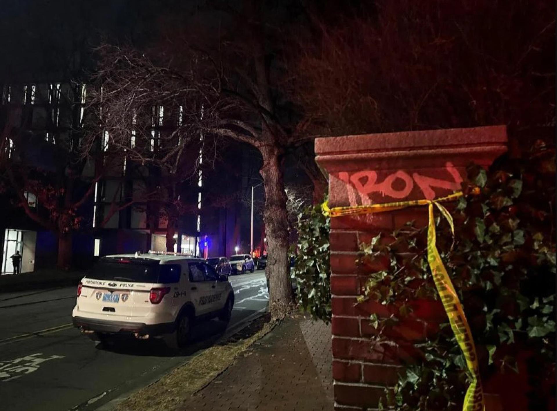 12月13日，美国布朗大学发生枪击事件后，一辆警车停在路边，旁边是一堵拉起警戒线的墙。