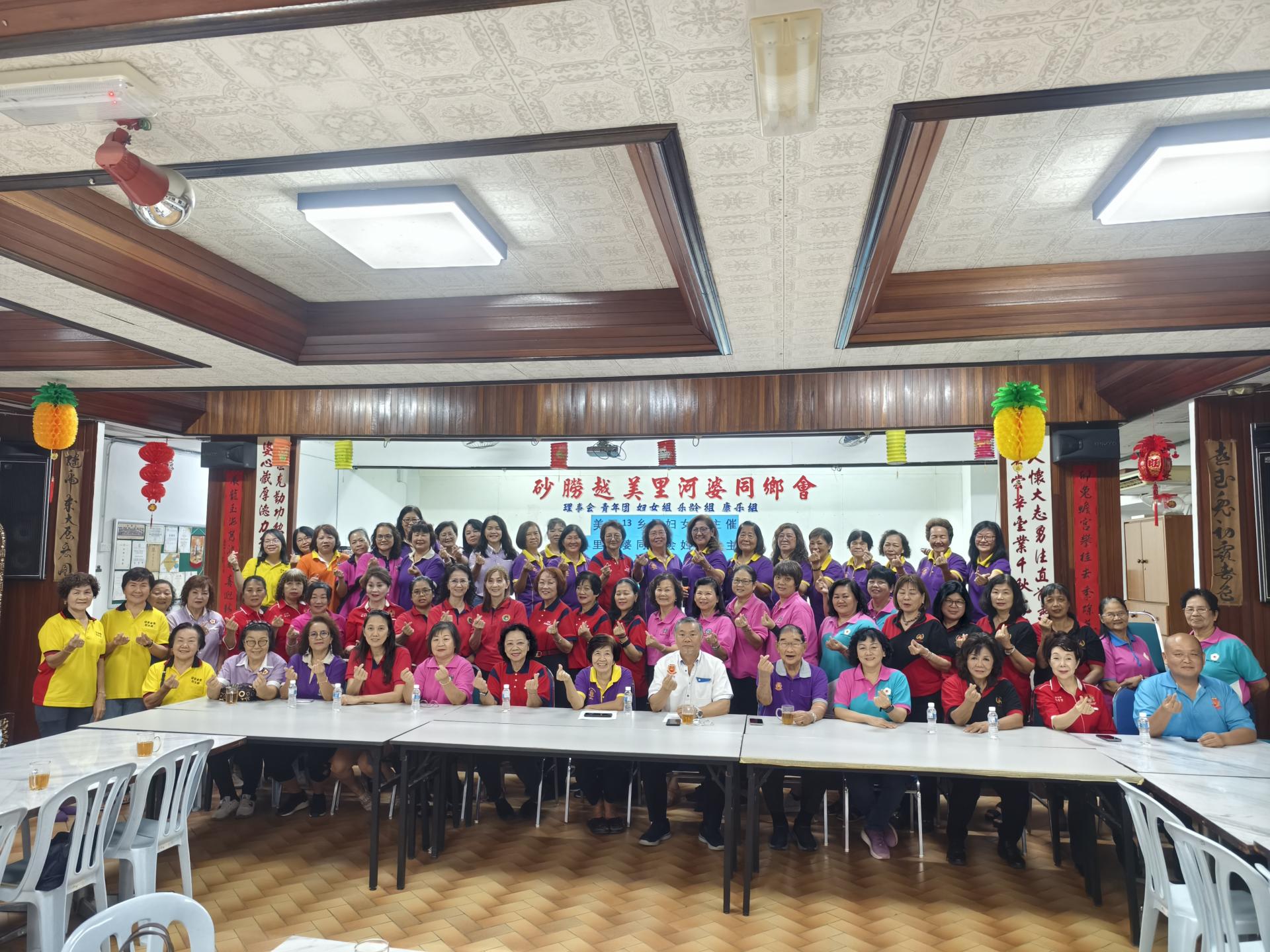 2025年第7届 13乡属美食分享交流会大合照。前排左起为美里诏安会馆妇女组主任沈隆妹，美里客家公会妇女组主任陈遵仁，美里广惠肇公会妇女组主任陈彩虹，美里兴安会馆妇女组主任卢贝贝，美里福州公会妇女组主任黄优芳，美里海南公会妇女组主任符丽兰，筹备会主席兼美里河婆同乡会妇女组主任蔡素芳，美里河婆同乡会会长蔡传创，美里河婆同乡会乐龄主任蔡真才，美里嘉应五属同乡会妇女组主任古秋英，美里大埔同乡会妇女组主任甲必丹陈彩萍，美里潮州公会妇女组主任吴宝贤，美里河婆同乡会青年团团长张鸿庆。