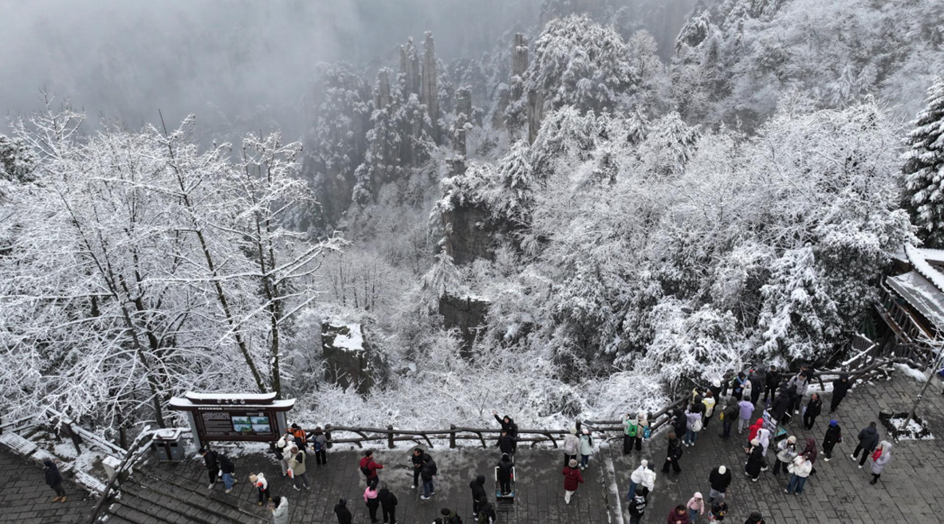 元旦假期第二天，游客来到湖南张家界国家森林公园。张家界赏雪季主要在冬季的12月至2月，其中1月最容易看到雪景、雾凇，山峰被白雪覆盖，宛如冰雪童话世界。（图：新华社）