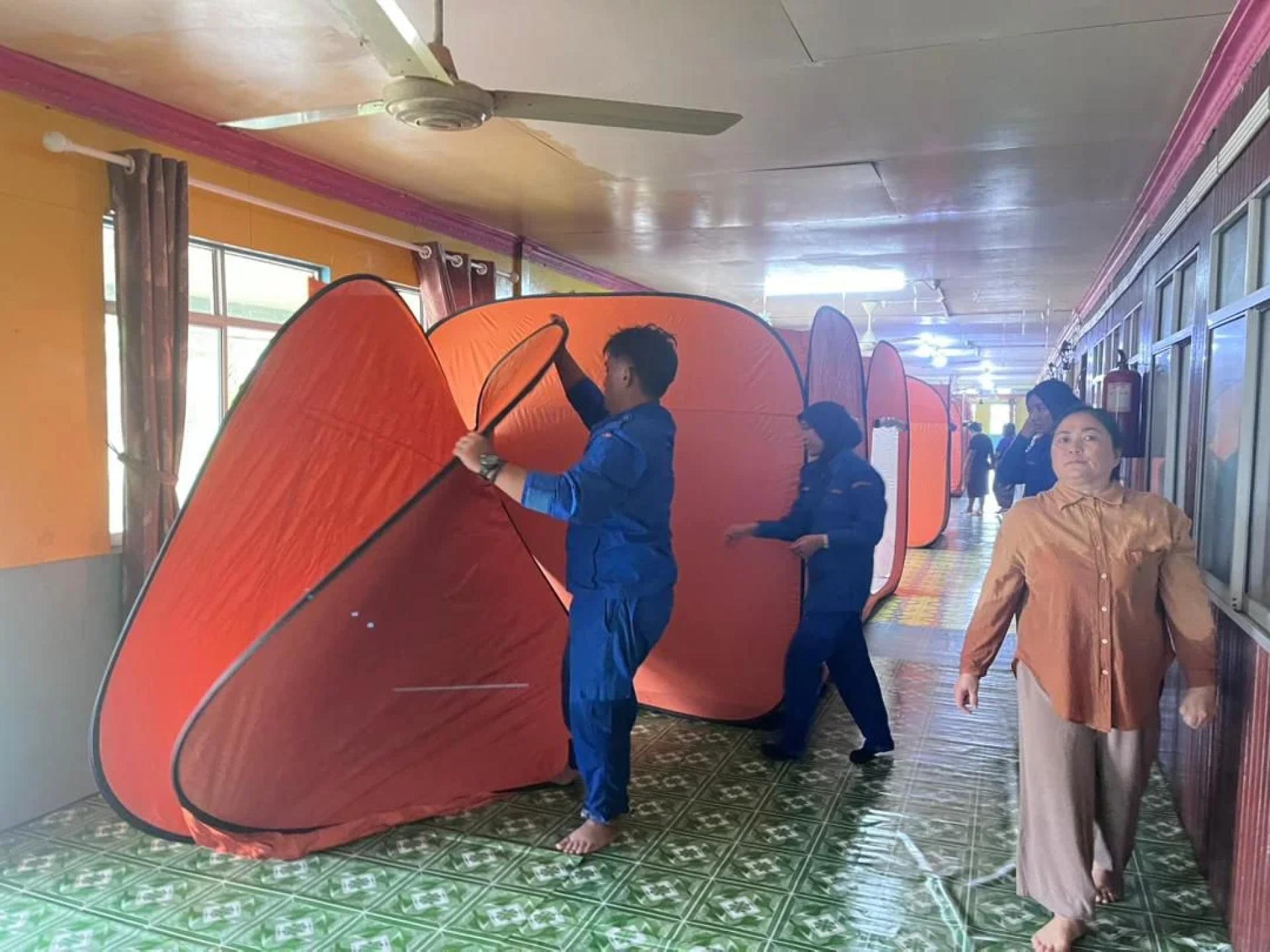 Anggota APM Dalat menguruskan mangsa di PPS Rumah James, Sebaya Atas, Sungai Baoh Burak, semalam.