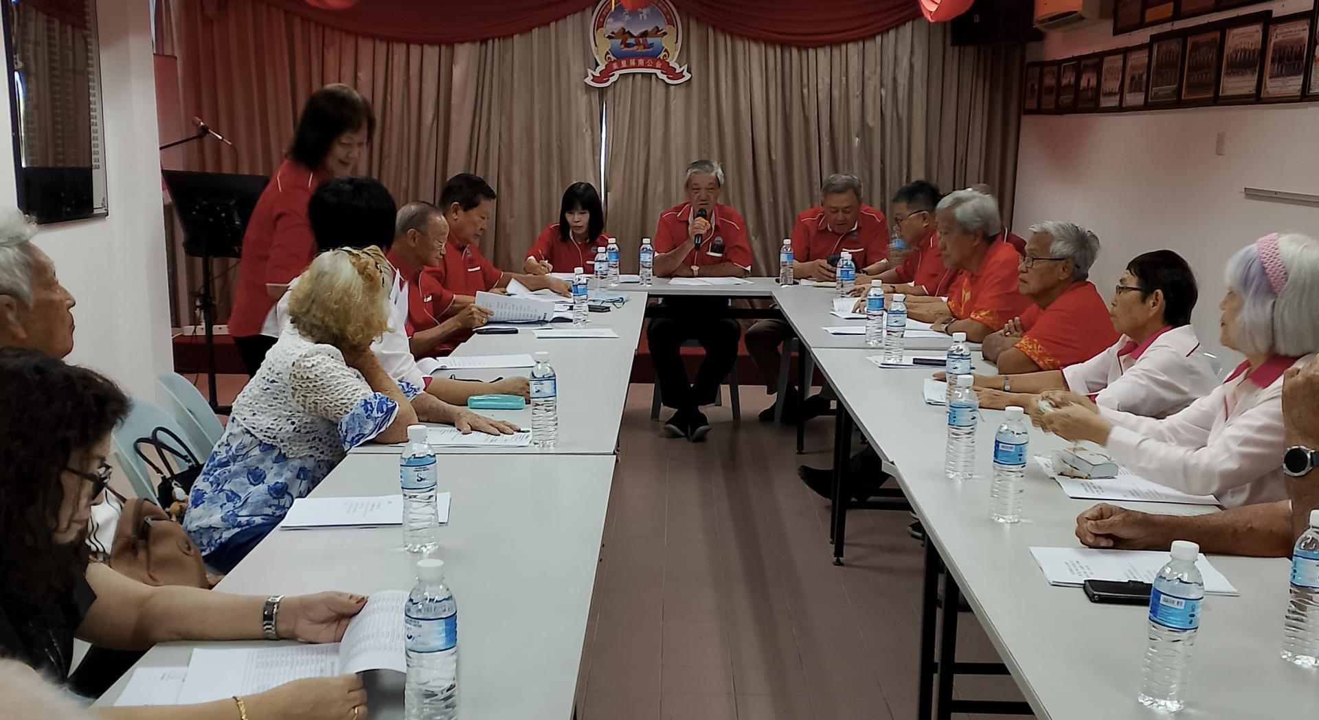 美里屏南公会乐龄组主任包金生（中）主持2026年组员大会  会议。右为会长陈家兴。