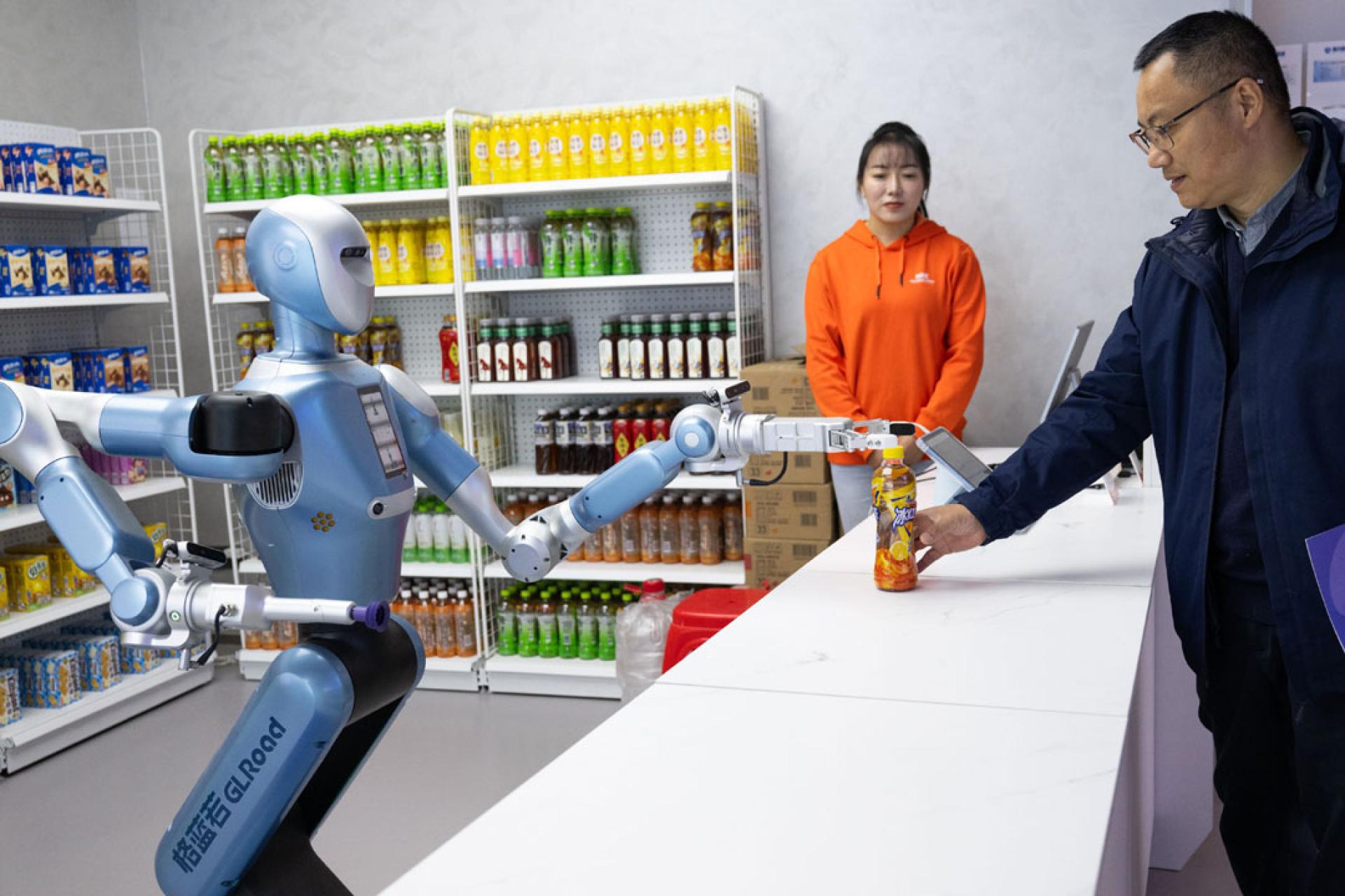 2025年12月4日，在中国湖北光谷人形机械人7S店，人形机械人从货架上抓取顾客选购的商品并拿给顾客。
