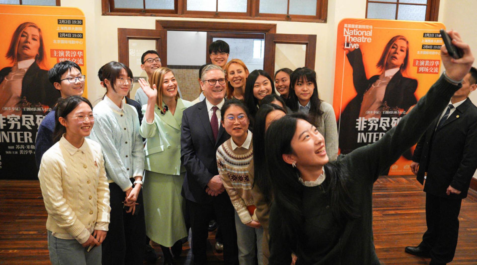 英国首相斯塔默（中）31日和英国演员兼制片人罗莎蒙德·派克（左二）在上海设计创新研究院与中国专业艺术表演的学生合影。