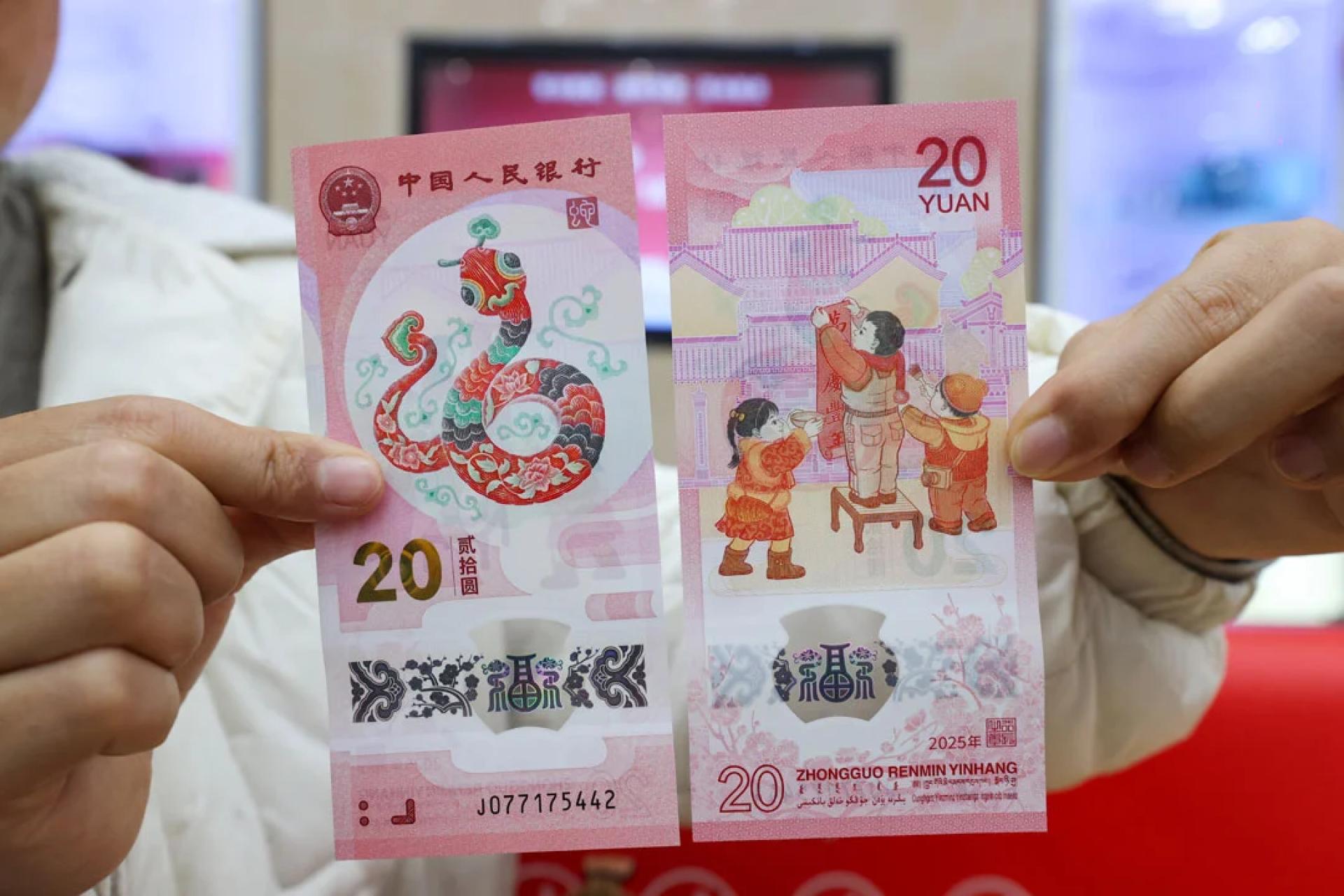 贵州贵阳市民在一家支行展示纪念钞。