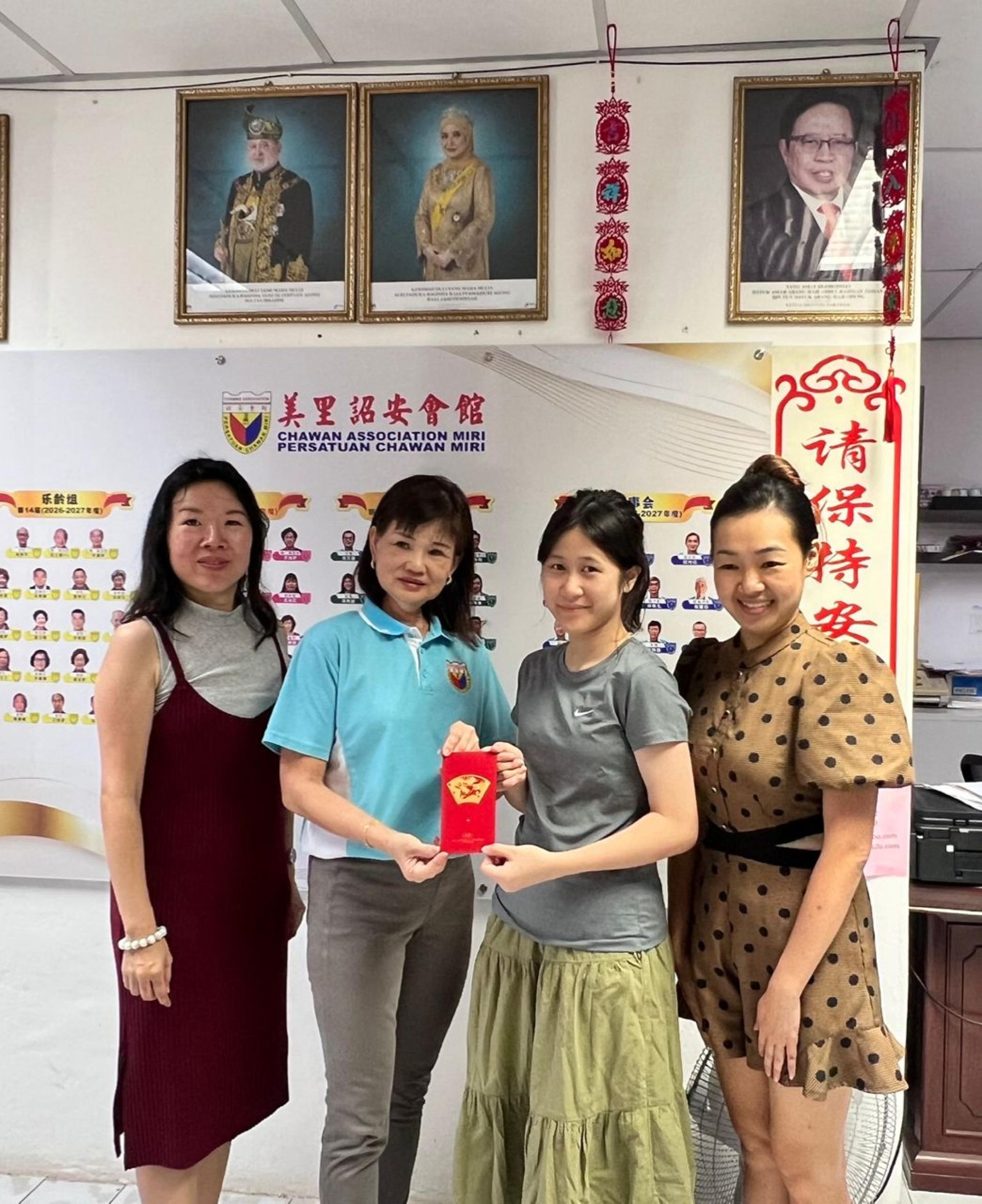 美里诏安会馆会长林美英（左2）颁发全砂小学书法比赛第4名予李芊宁（右2）。