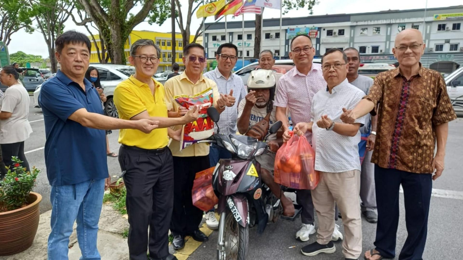 天猛公拿督陈如飞（右3）与许义华（右起）、薛华东布施食品予一印裔特殊人士。右起为田云华、张联通、拿督龚财兴；左4是拿督蔡传伟。