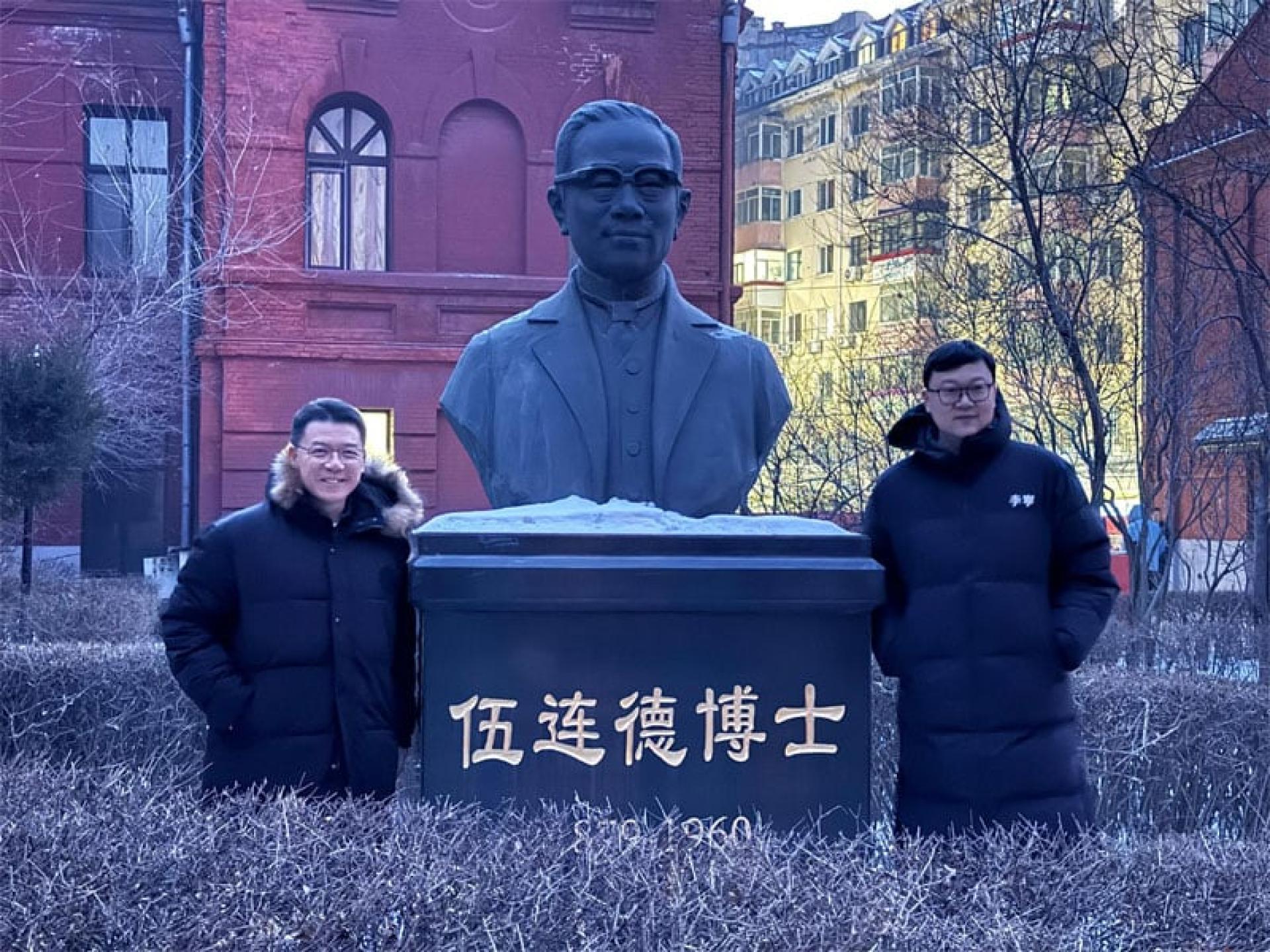 倪可敏与伍连德博士铜像进行合影。右为哈尔滨省政府首外联络处处长张进博。