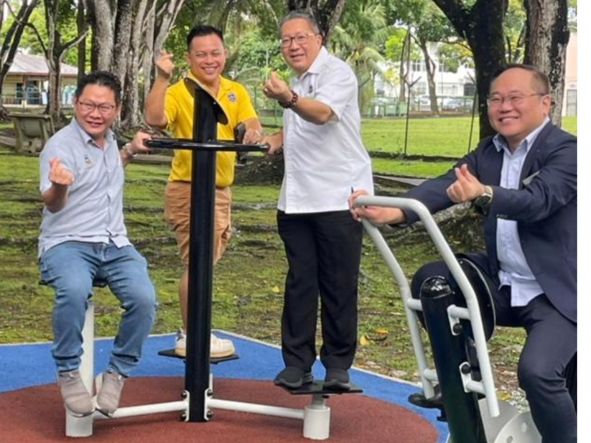 南市市长拿督黄鸿圣（右2）对提升后的公园健身设施感到满意。