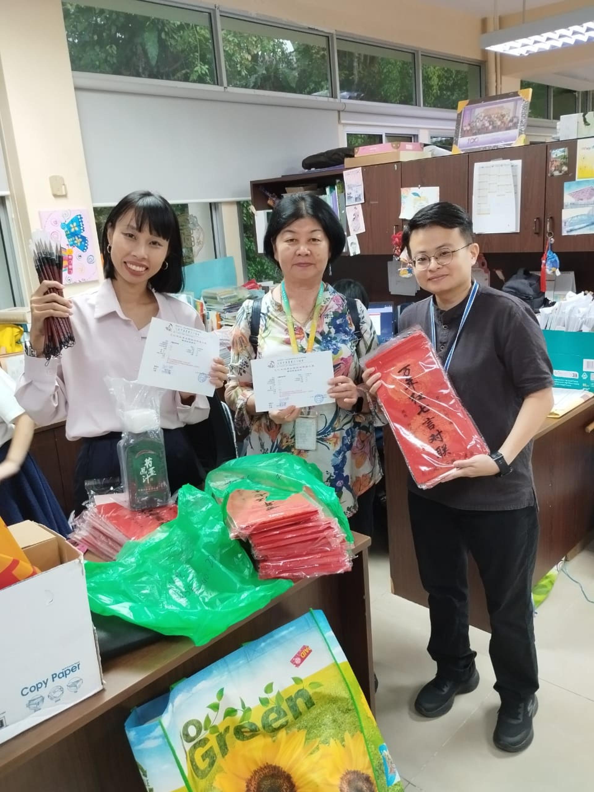 参赛学生人数最多的汶莱中华中学，华文部主任邓巧玲、贝荣彩及文协理事陈美兰老师领取书法文具