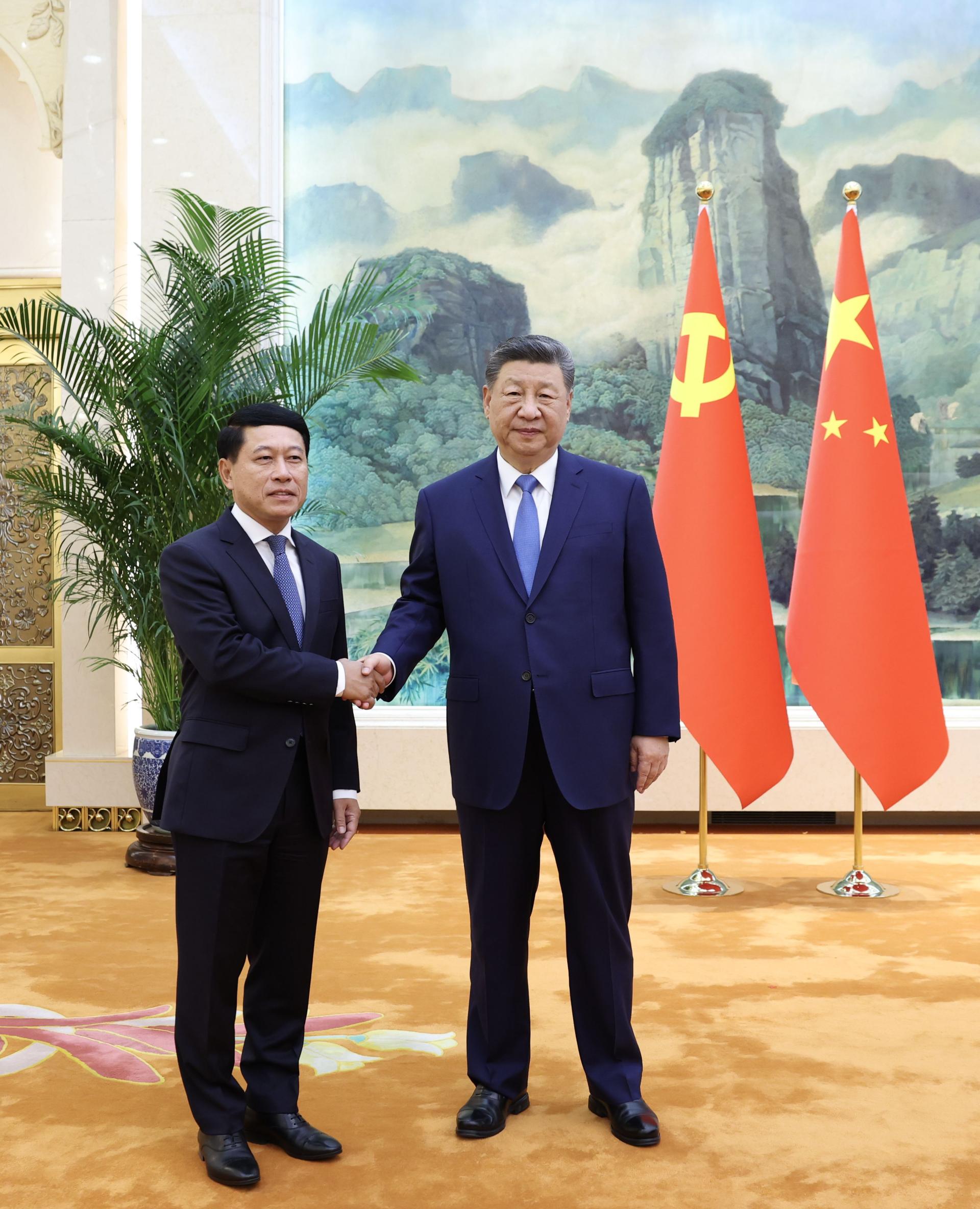 中国国家主席习近平（右）21日下午在北京会见访华的寮国常务副总理沙伦赛。（图：新华社）