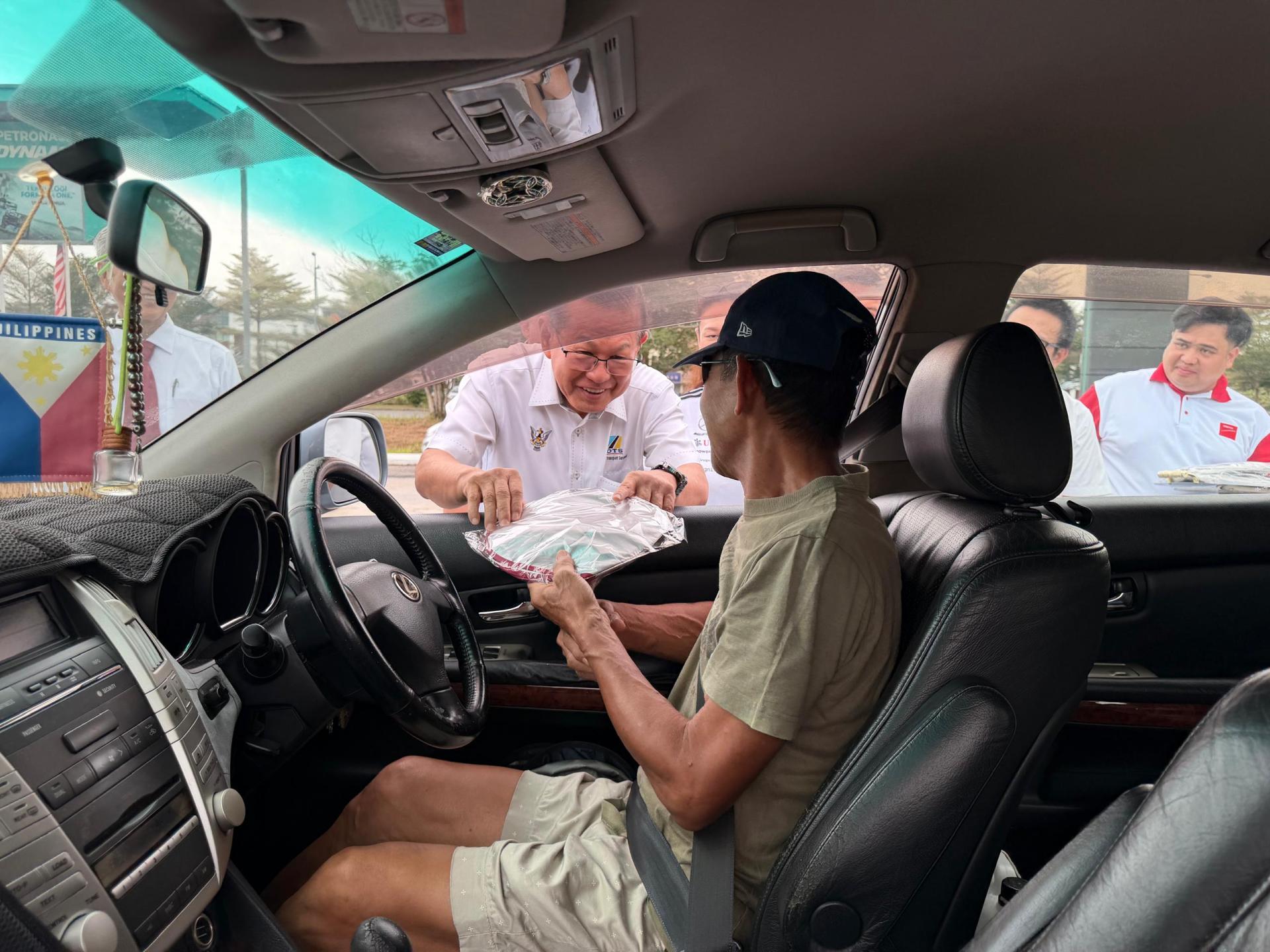 拿督斯里李景胜派发安全手册等予道路使用者时摄。
