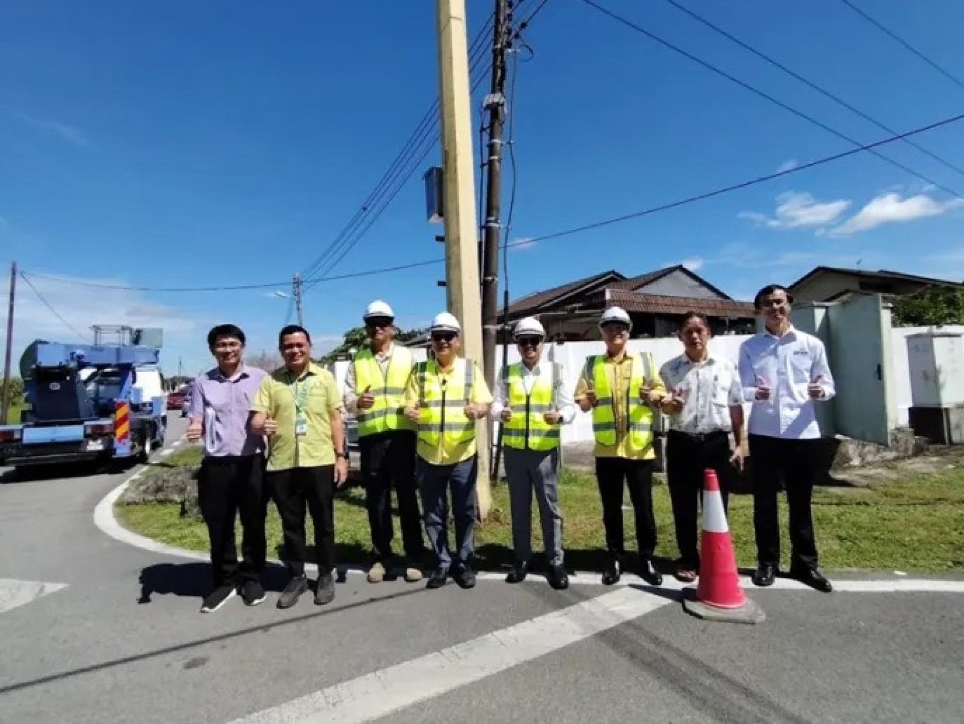 罗克强（左4）于2026年5月5日在阿兰路主持闭路电视系统启用仪式后与众人合影。