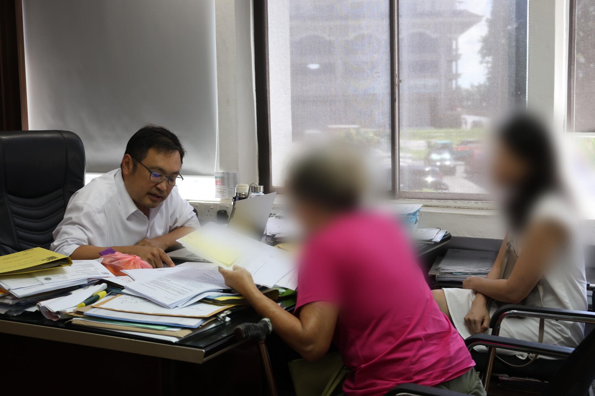 退休女教师（中）在家人的陪同下，向砂行动党国州议员张健仁求助，以追回失款。