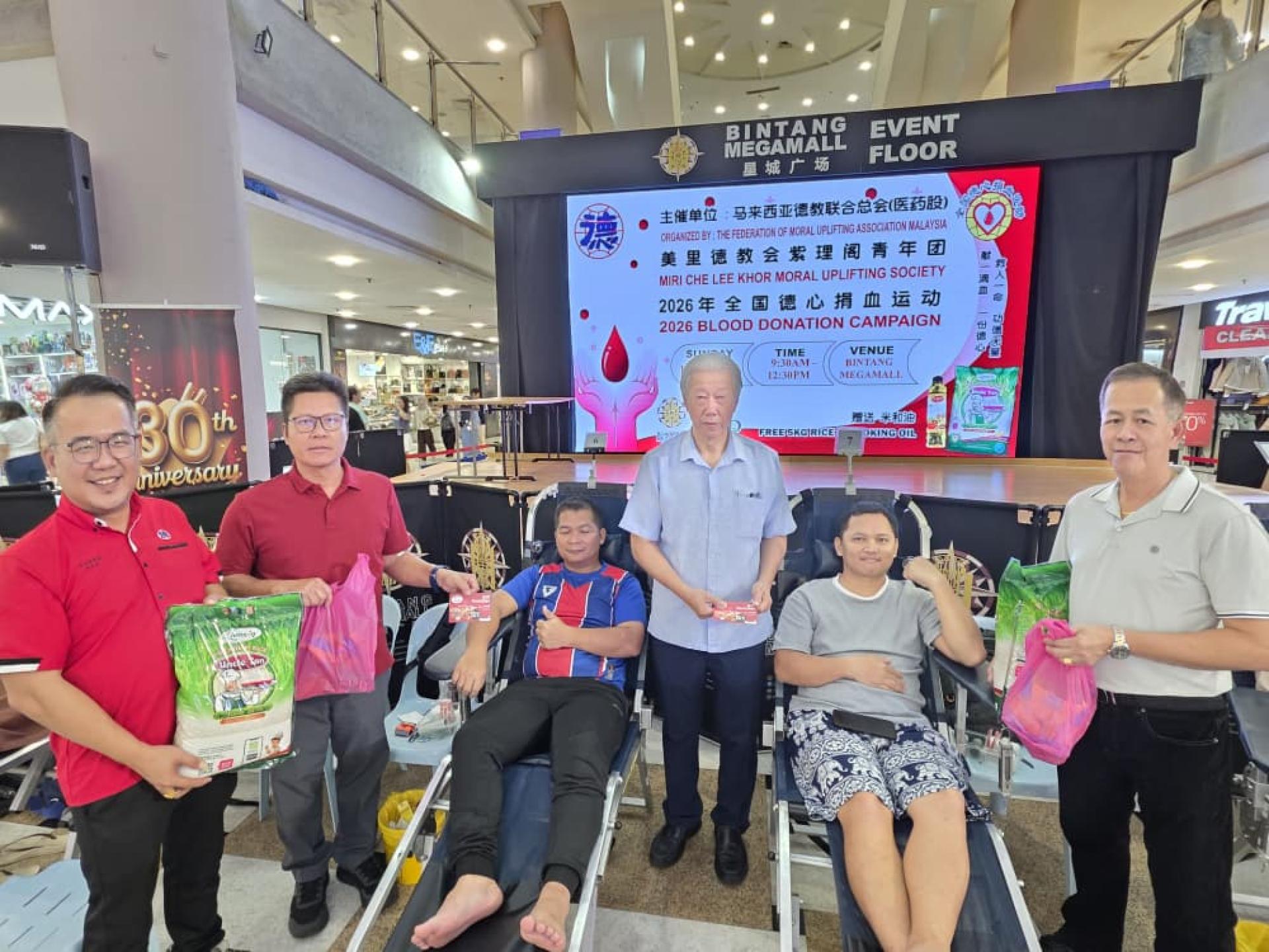 成功捐血者获赠5公斤白米及食用油。图中为阁长贝清湛与理事和成功捐血的民众合影。