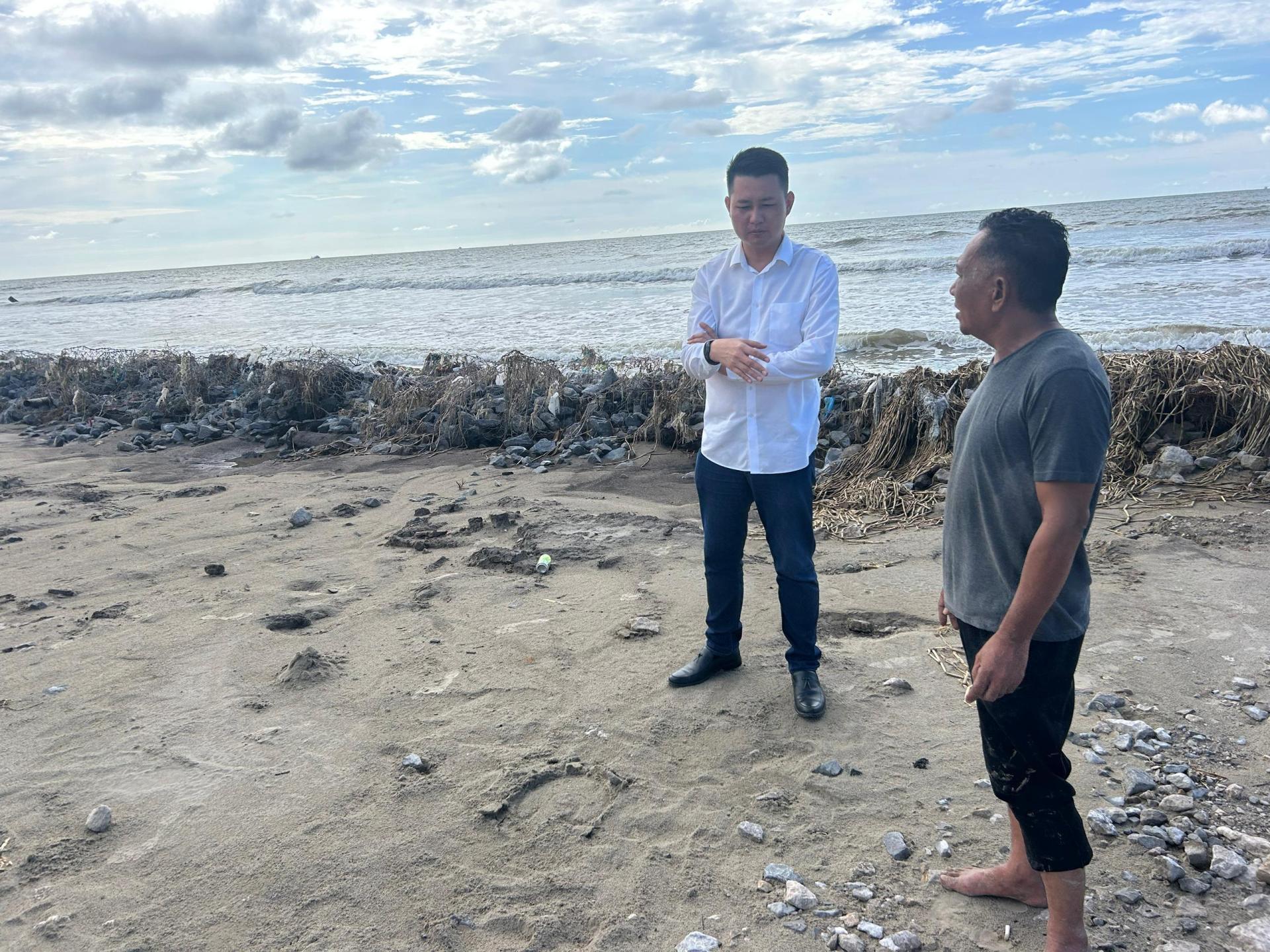 美里罗东海岸线严重被侵蚀，砂行动党秘书林思健（左）到海边向当地民众了解情况。
