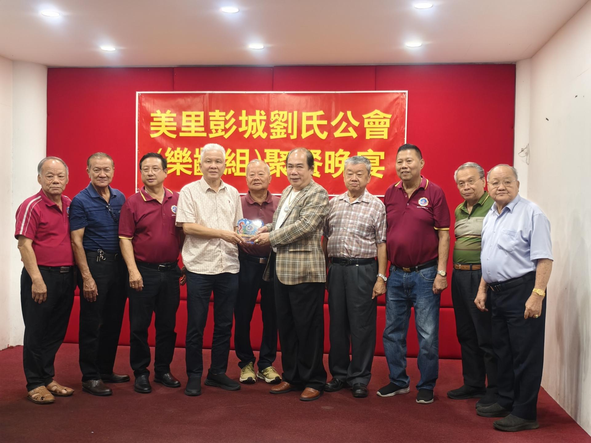 美里彭城刘氏公会主席刘嘉治（左4）在名誉会长拿督斯里刘久健（左5）见证及嘉宾陪同下，赠送纪念品给乐龄组聚餐晚宴总赞助人刘世定（右5）。左起为刘汉平、署理会长刘守忠、筹备会主席刘守辉；右起为刘恭光、刘恭庆、乐龄组主任刘美昌，以及刘仁华。