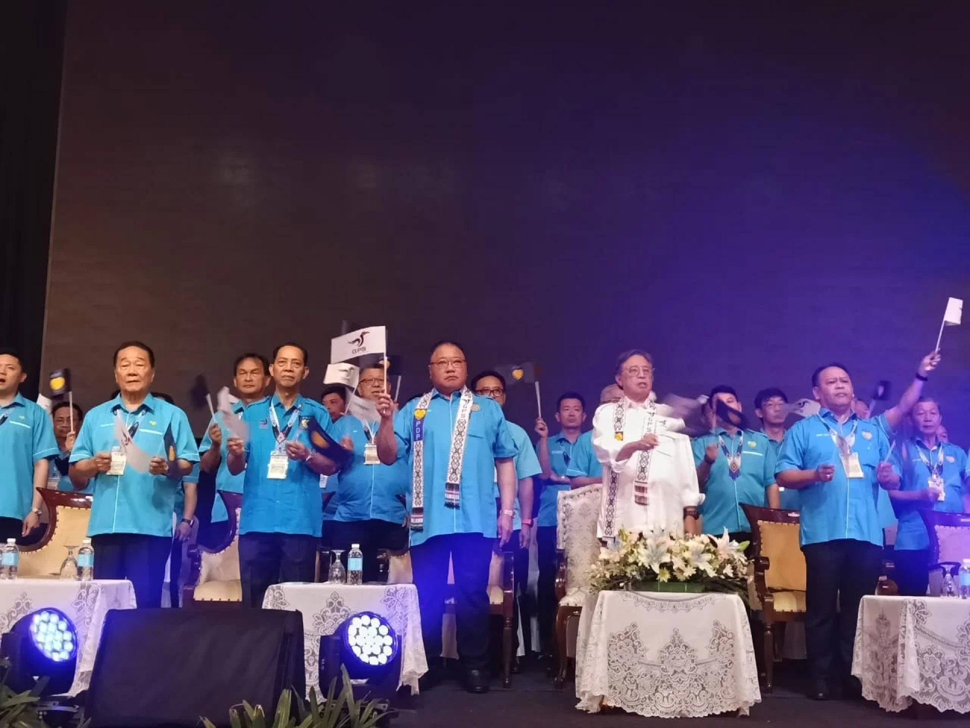 砂总理拿督巴丁宜丹斯里阿邦佐哈里（中）联同拿督斯里张庆信及民进党员，在该党的三年一度代表大会开幕礼上，高举砂政党联盟旗帜。