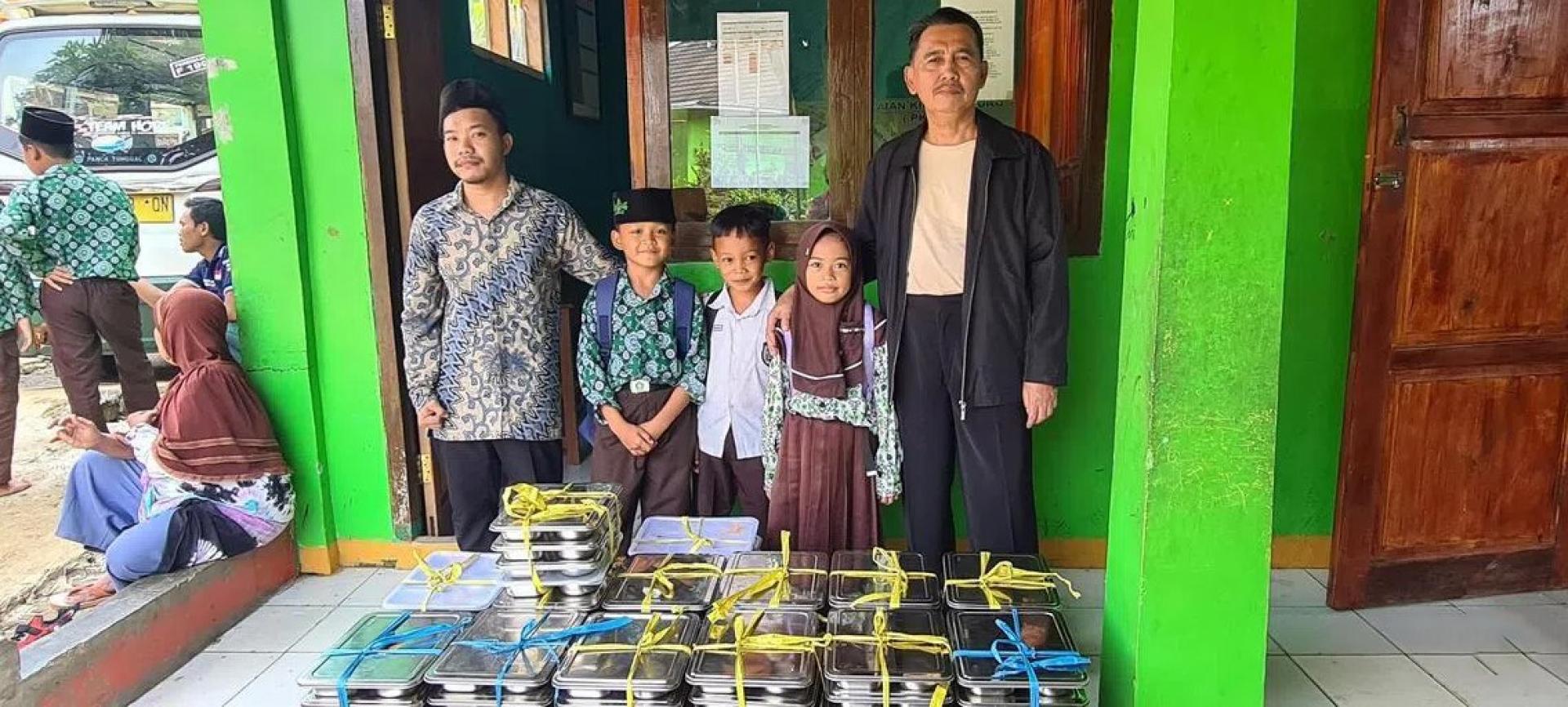 印度尼西亚西爪哇省苏加武眉县格拉萨里伊斯兰小学的校长沙拉胡丁·萨努西（右）监督学校免费午餐计划的试行。