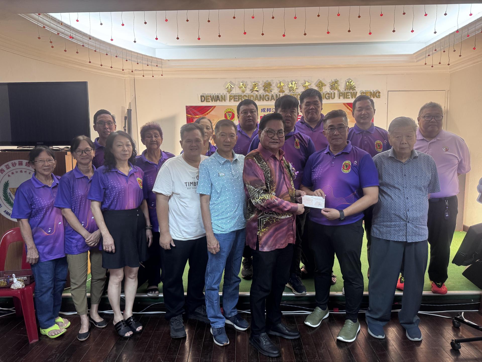 拿督吴标生（左6）移交1万马币捐款，由成邦江音乐社主席张詠淳接领。