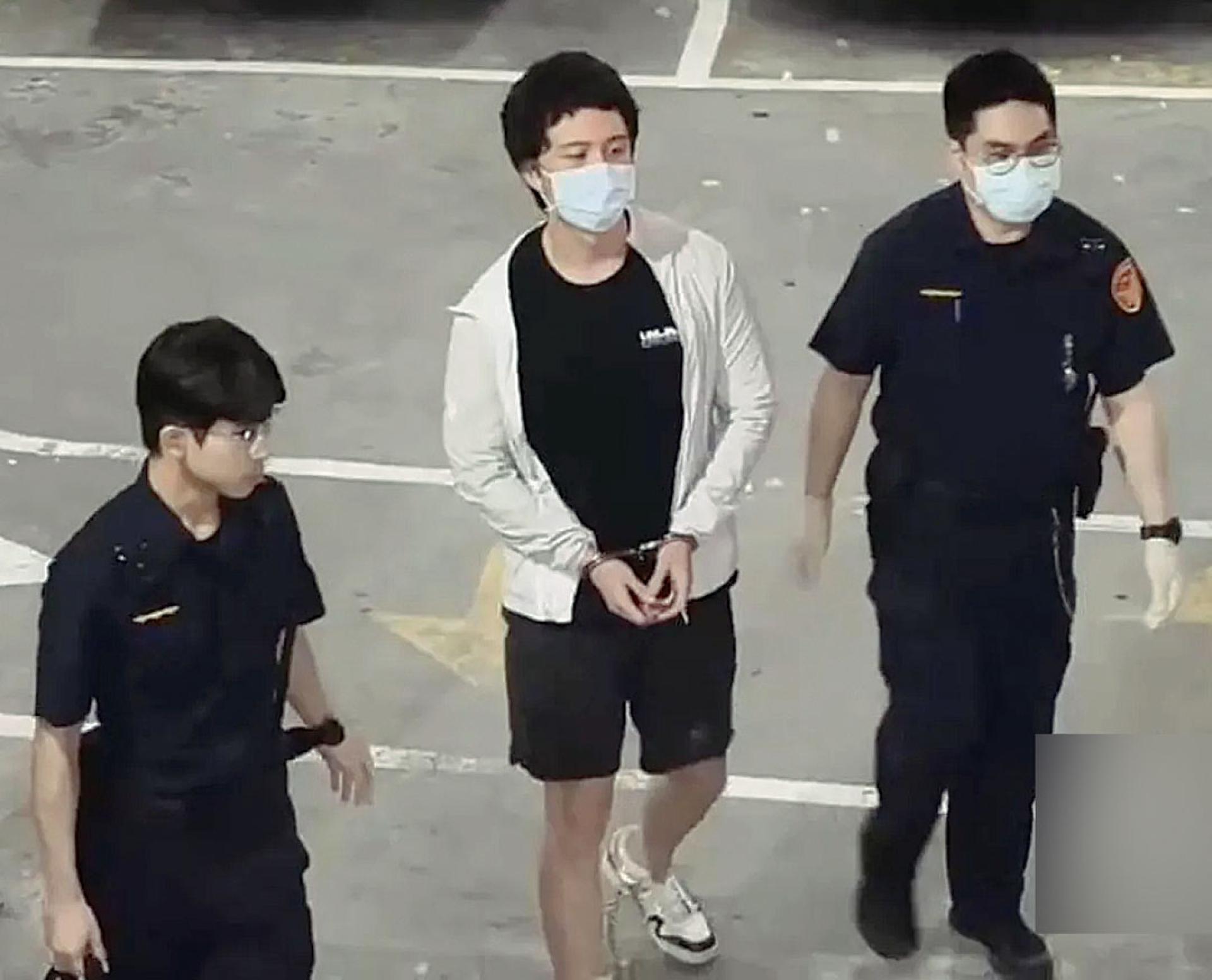 孙安佐（中）被羁押后，被上手铐、脚镣踏上囚车。
