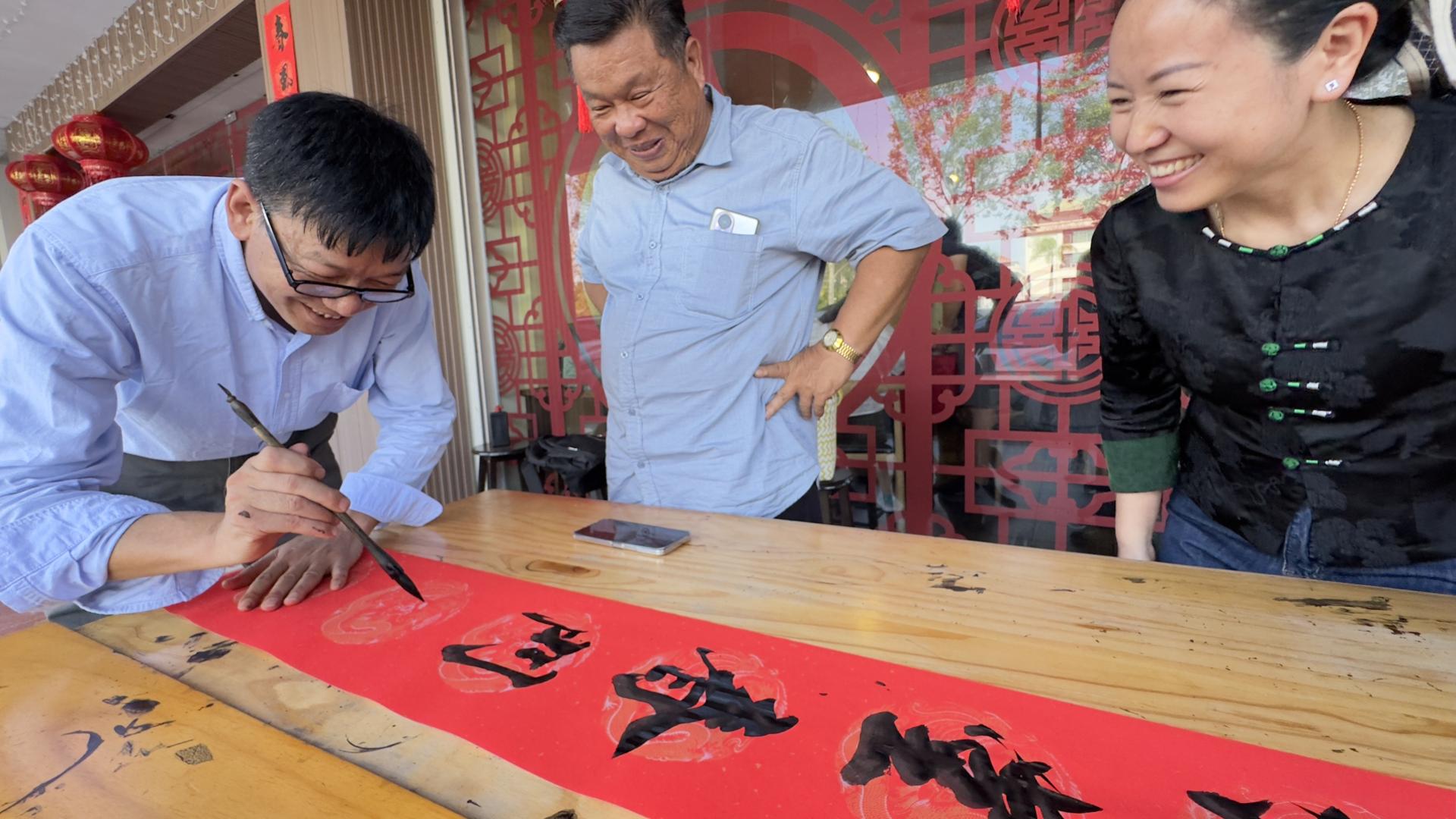 中国“当代最受欢迎艺术家”朱建良（左1）挥毫时赢得现场人士的热烈赞赏。右2为拿督阮兴德。
