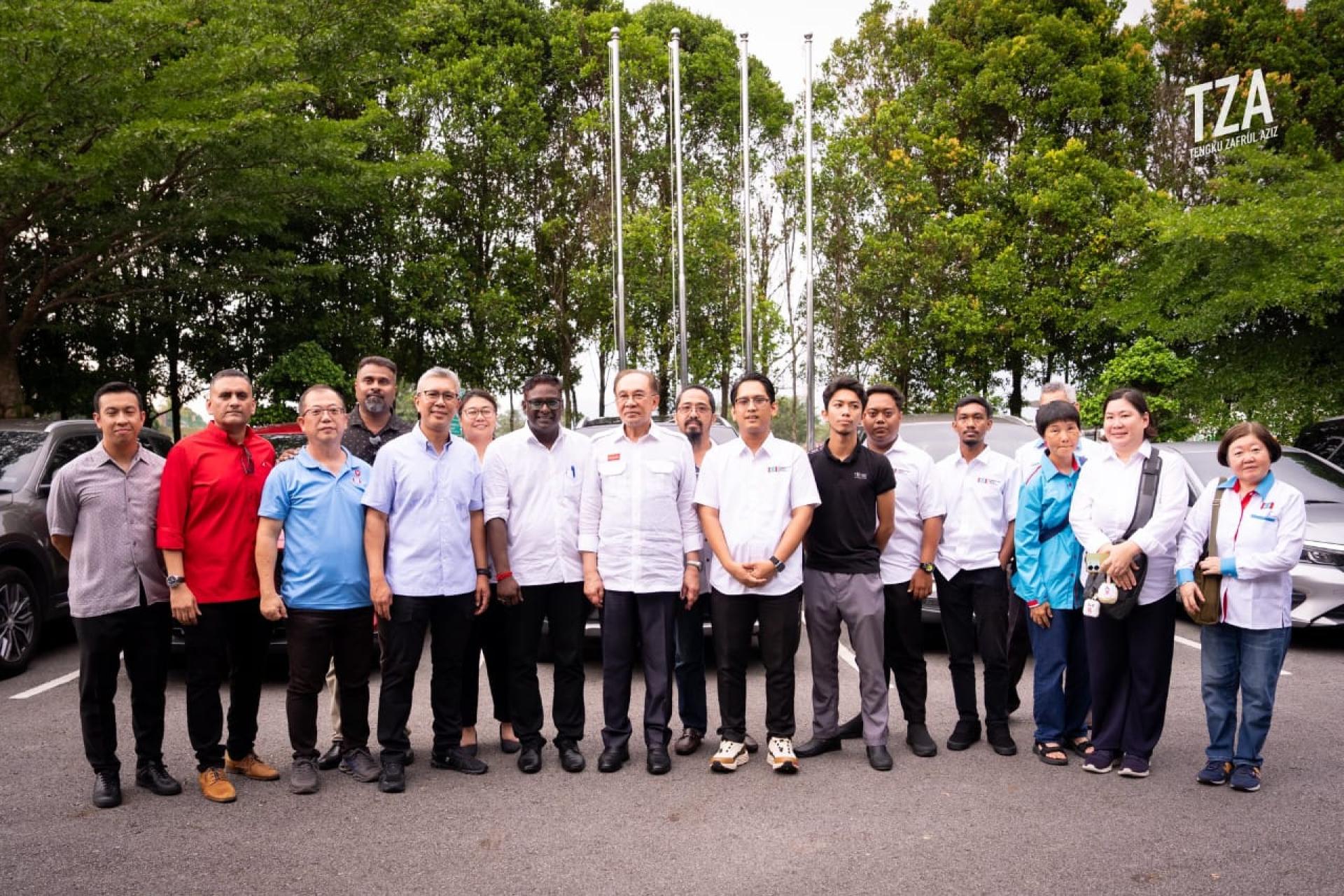 在东姑扎夫鲁（前左4）的牵线下，公正党班丹区部领袖与党主席安华（前左6）会面及合影。
