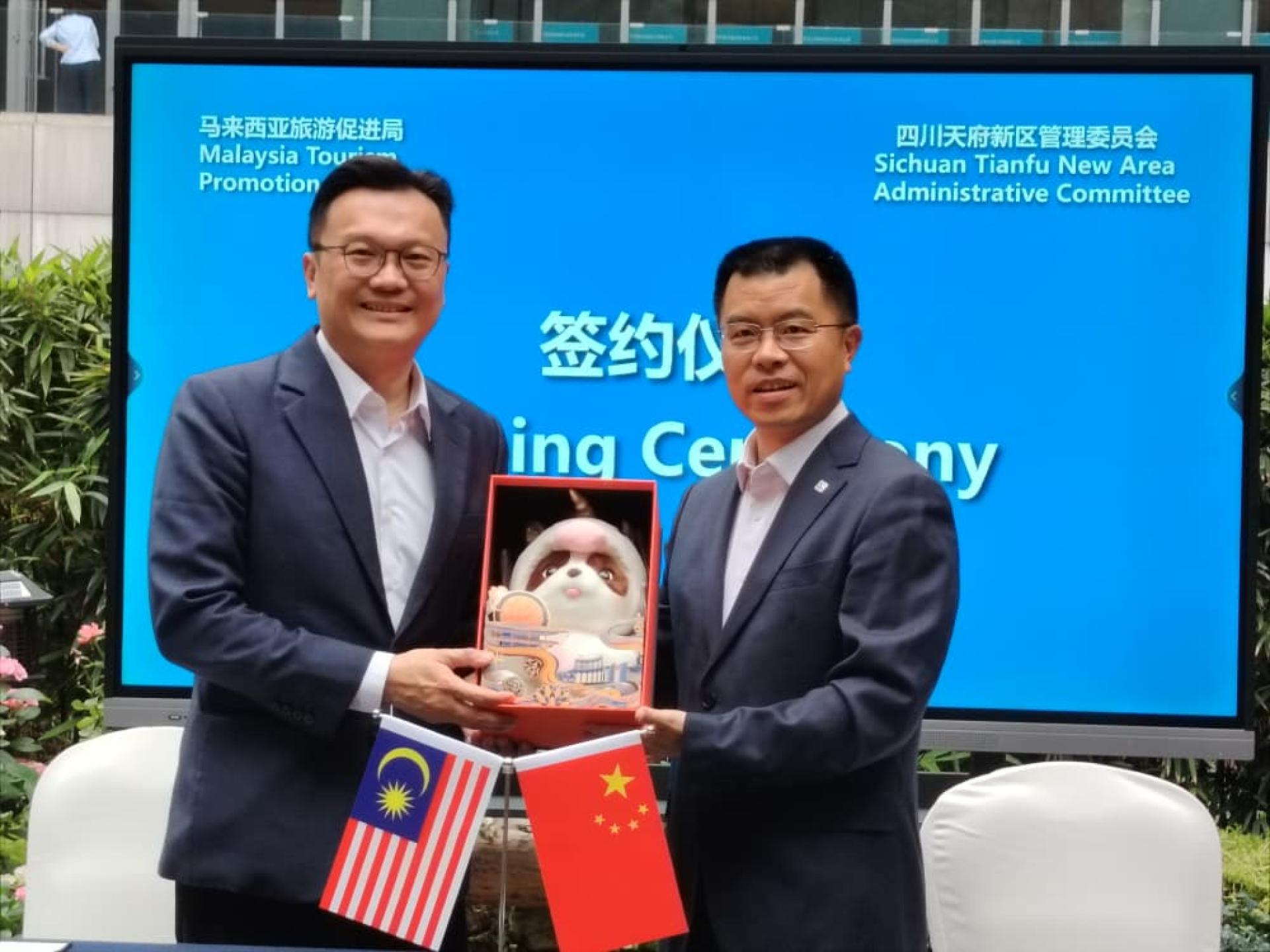 杨顺兴（左）与冯秀福（右）签约后交换纪念品。