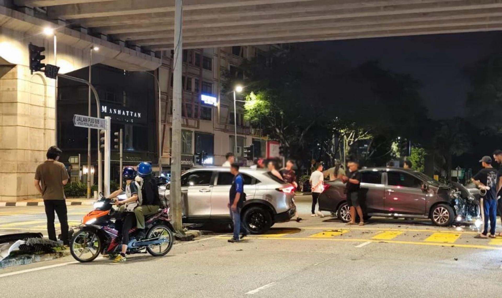 两辆车子在路口发生车祸，路过民众驻足围观。