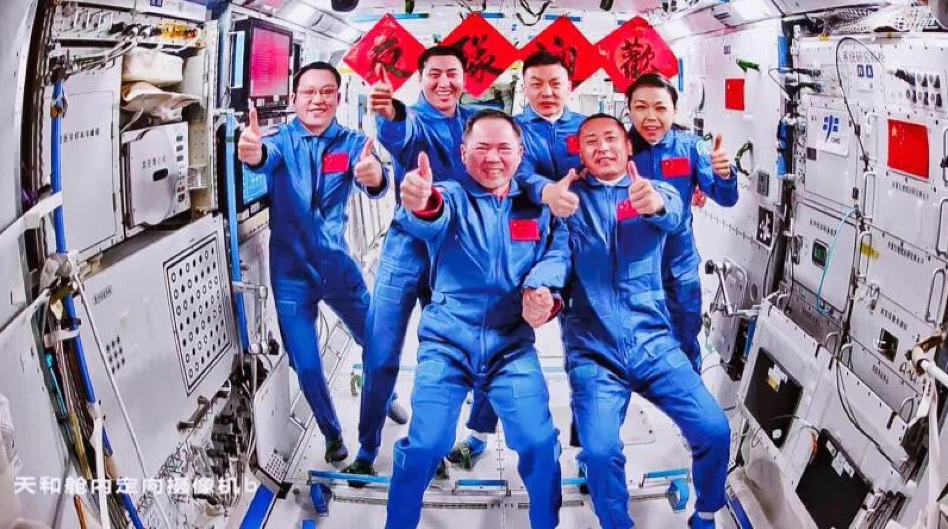 星期一（5月25日）在北京航天飞行控制中心飞控大厅拍摄的神舟21号航天员乘组和神舟23号航天员乘组拍摄合照的实时画面。