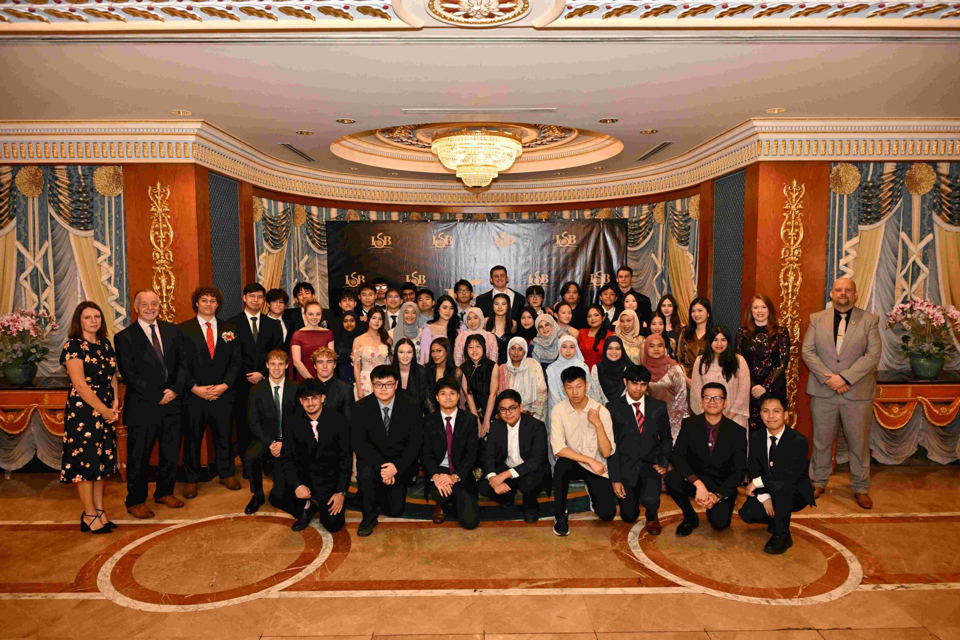 汶莱国际学校 (ISB) 2026 届 13 年级毕业生与 ISB 执行校长多米尼克莫利以及 ISB 的教师和员工在 毕业典礼上合影