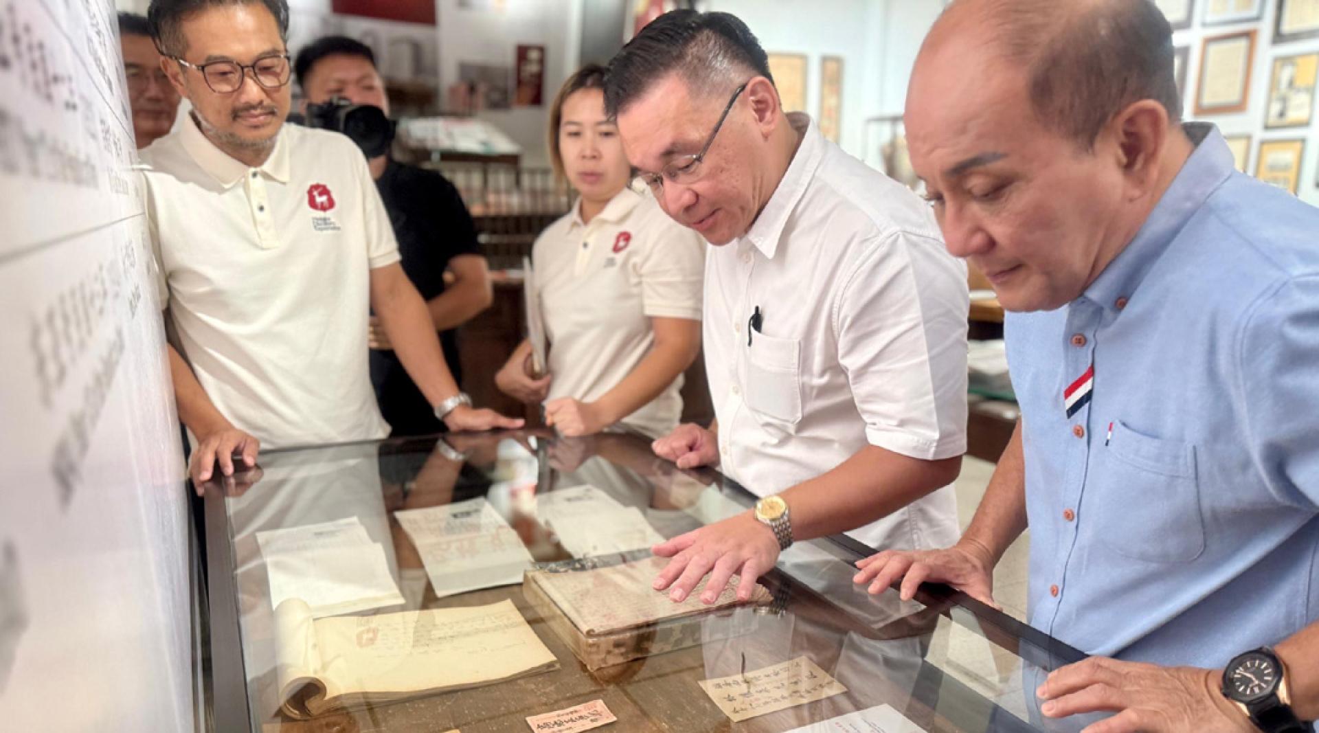 5月25日，马来西亚中国公共关系协会副会长颜天禄（右二）在马六甲百年老字号郑锦元酿酒厂体验馆观看侨批。（受访者供图）