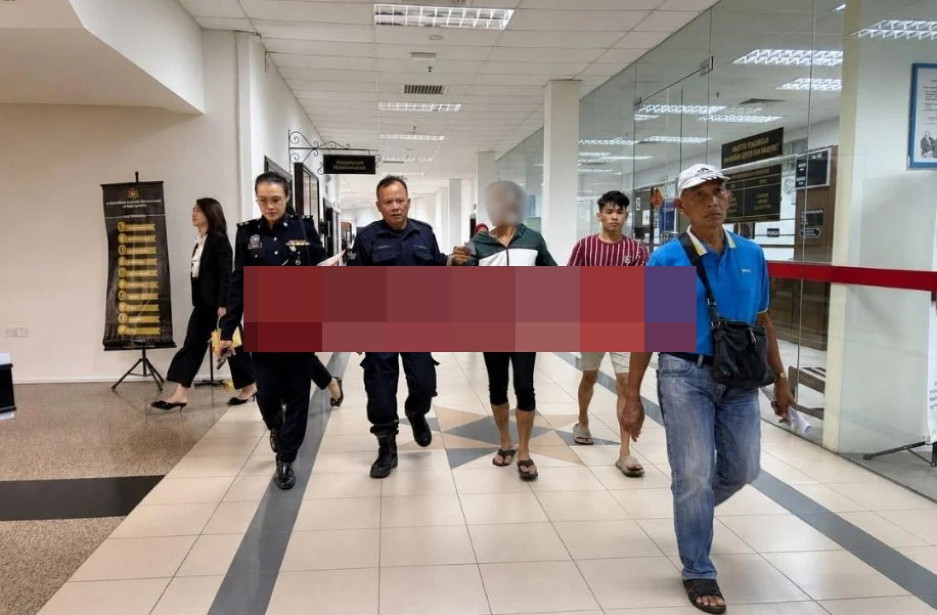 被告（身穿绿色与白色上衣）在警方押送下离开法庭。