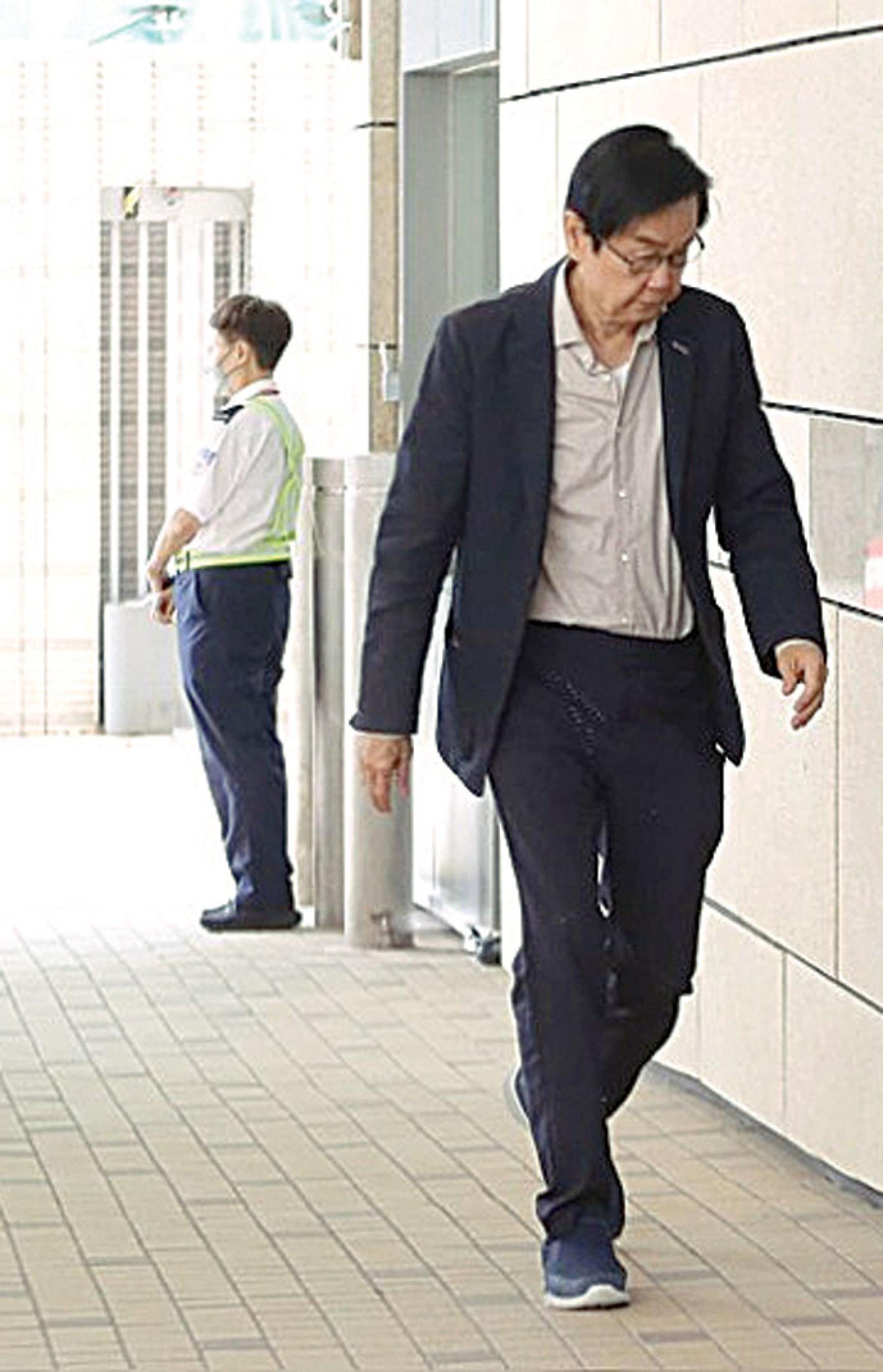 黄百鸣9日低头无言步入法庭。