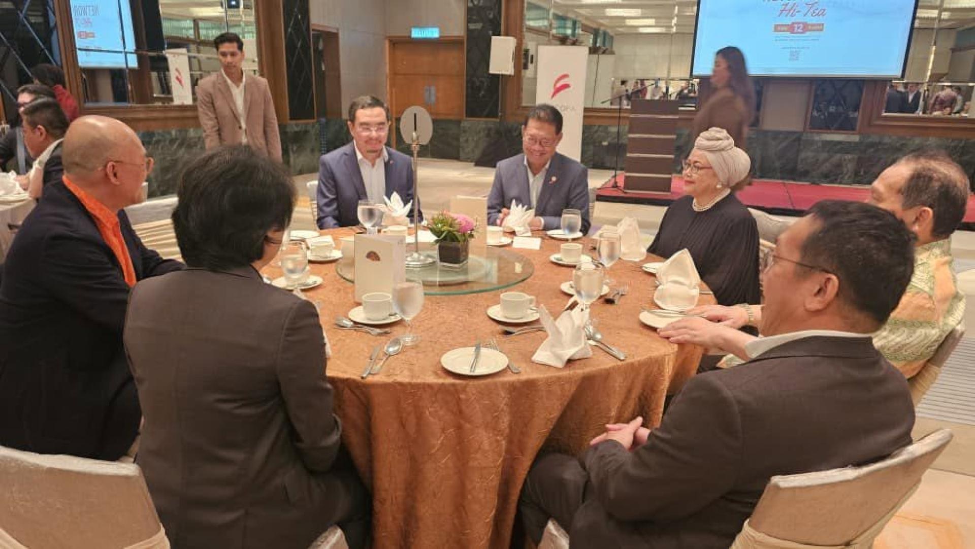拿督斯里朱莱希（中）与出席茶会主宾桌者交流。