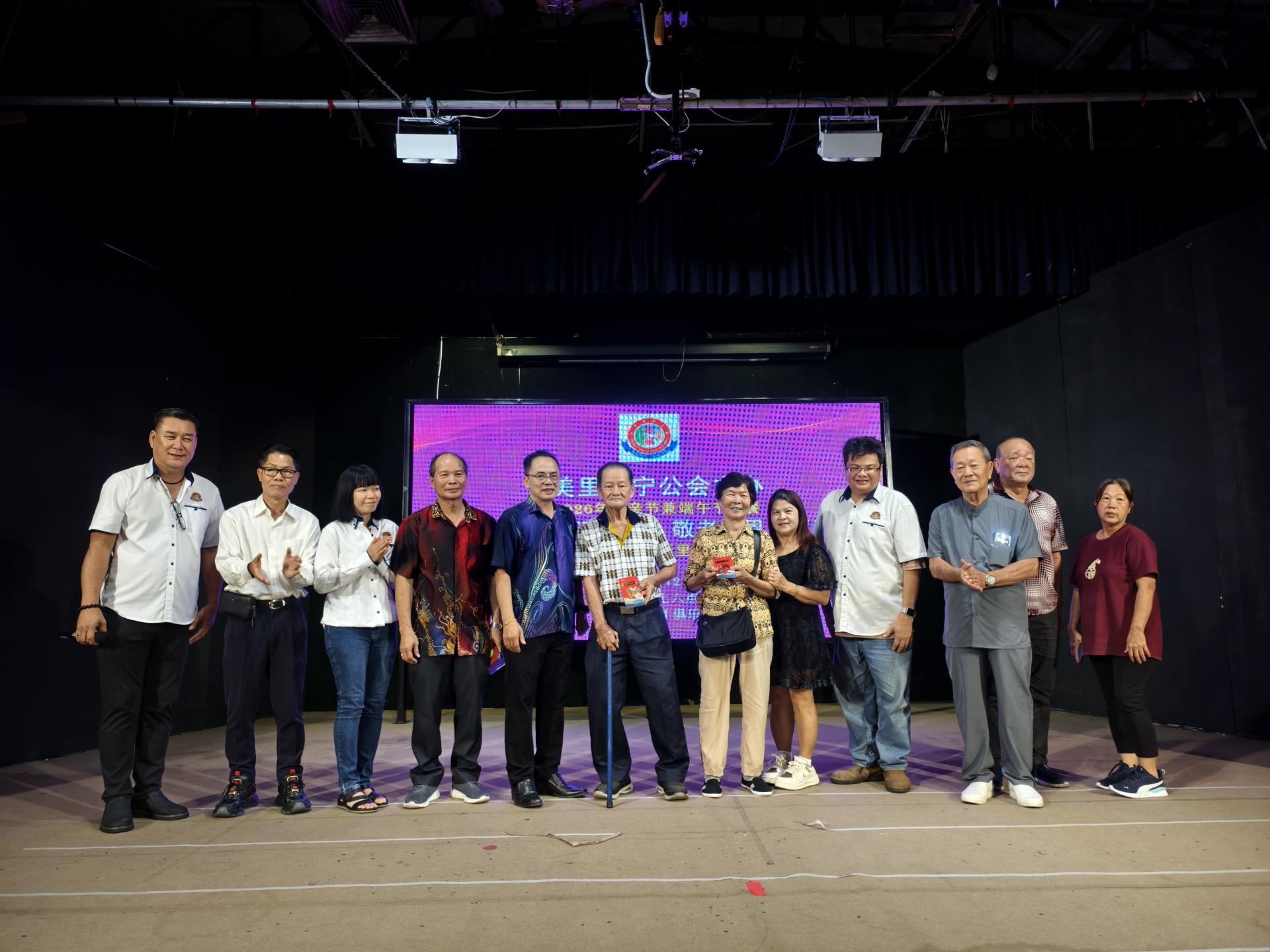 邵米华（左5）在美里广宁公会双亲节暨端午节庆祝晚宴上颁发红包给现场最高龄男女长者，85岁的沈其高（男）及江新娣（女）合影。