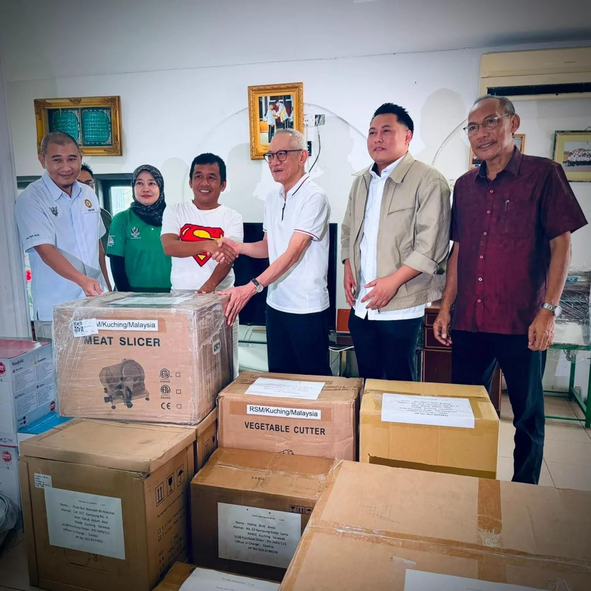 SERAH… Ibrahim menyampaikan peralatan dan mesin kepada usahawan tempatan di kawasan Satok pada majlis penyerahan berkenaan, hari ini.