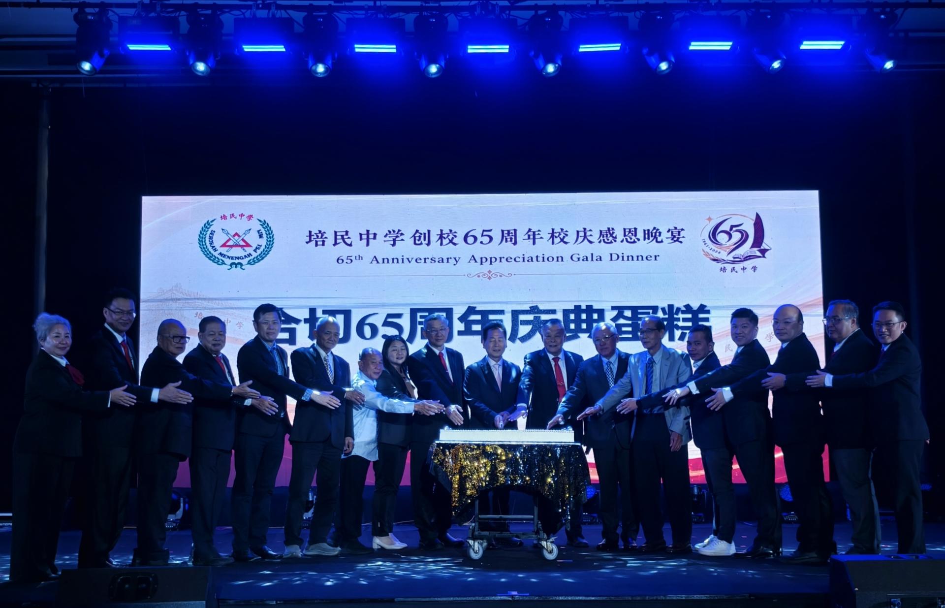 嘉宾与董教成员共同切65周年校庆蛋糕。