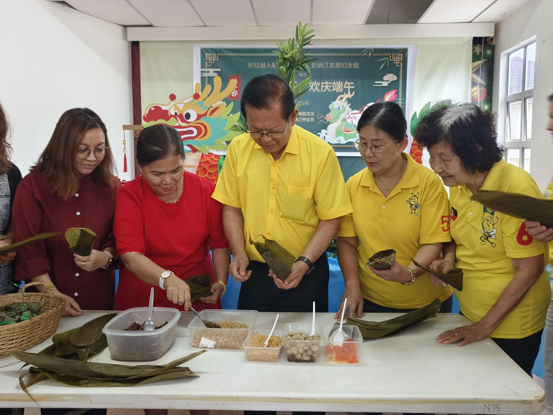 拿督斯里李景胜（左3）与友族党员踊跃参与包粽子活动，与众人一同感受浓厚的端午佳节氛围。右2为妇女组主任田秀兰市议员。