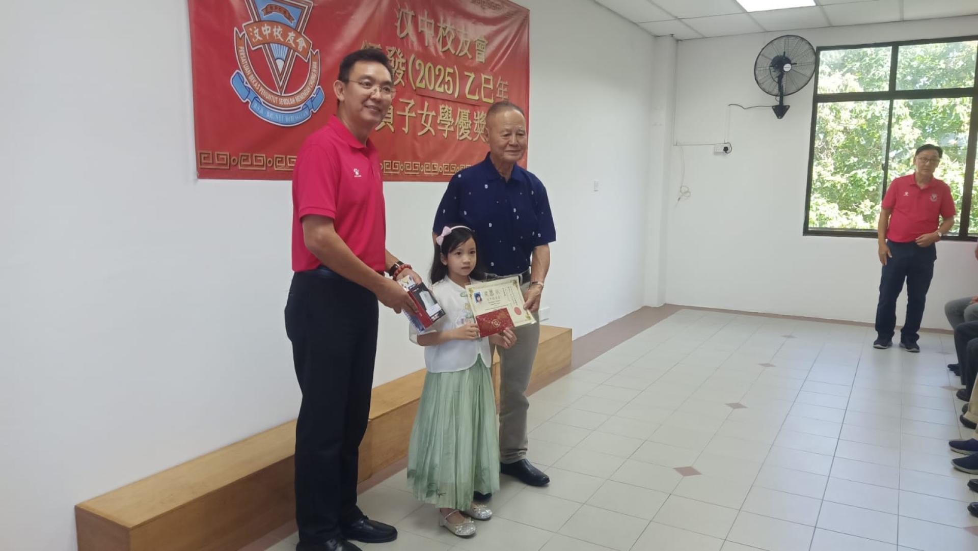魏菠佛移交奖励金予会员子女，左为汶中校友会林伟发会长