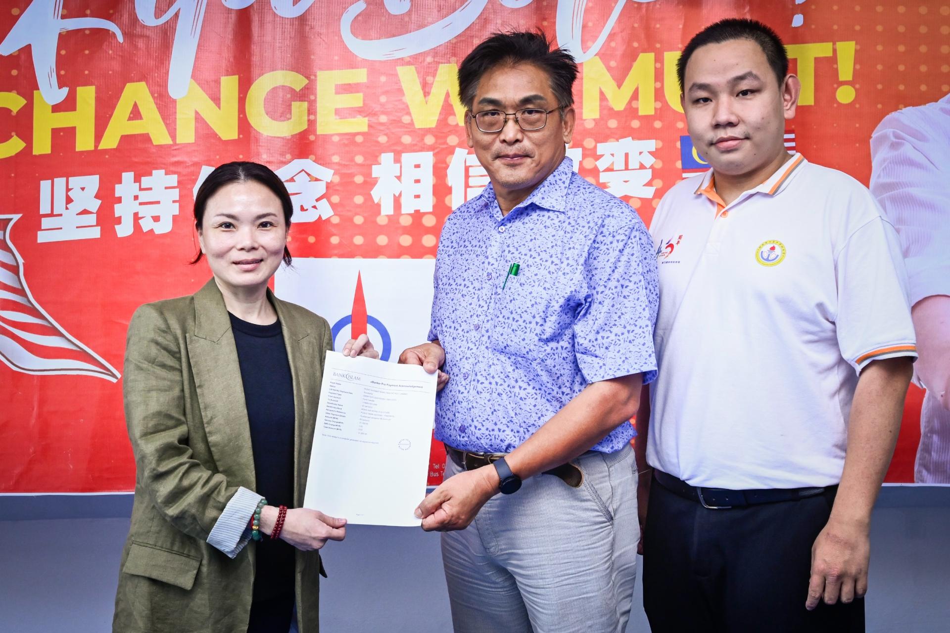 刘强燕（左1）颁发特别奖励金予黄乃裳中学校长卢友雄时摄。