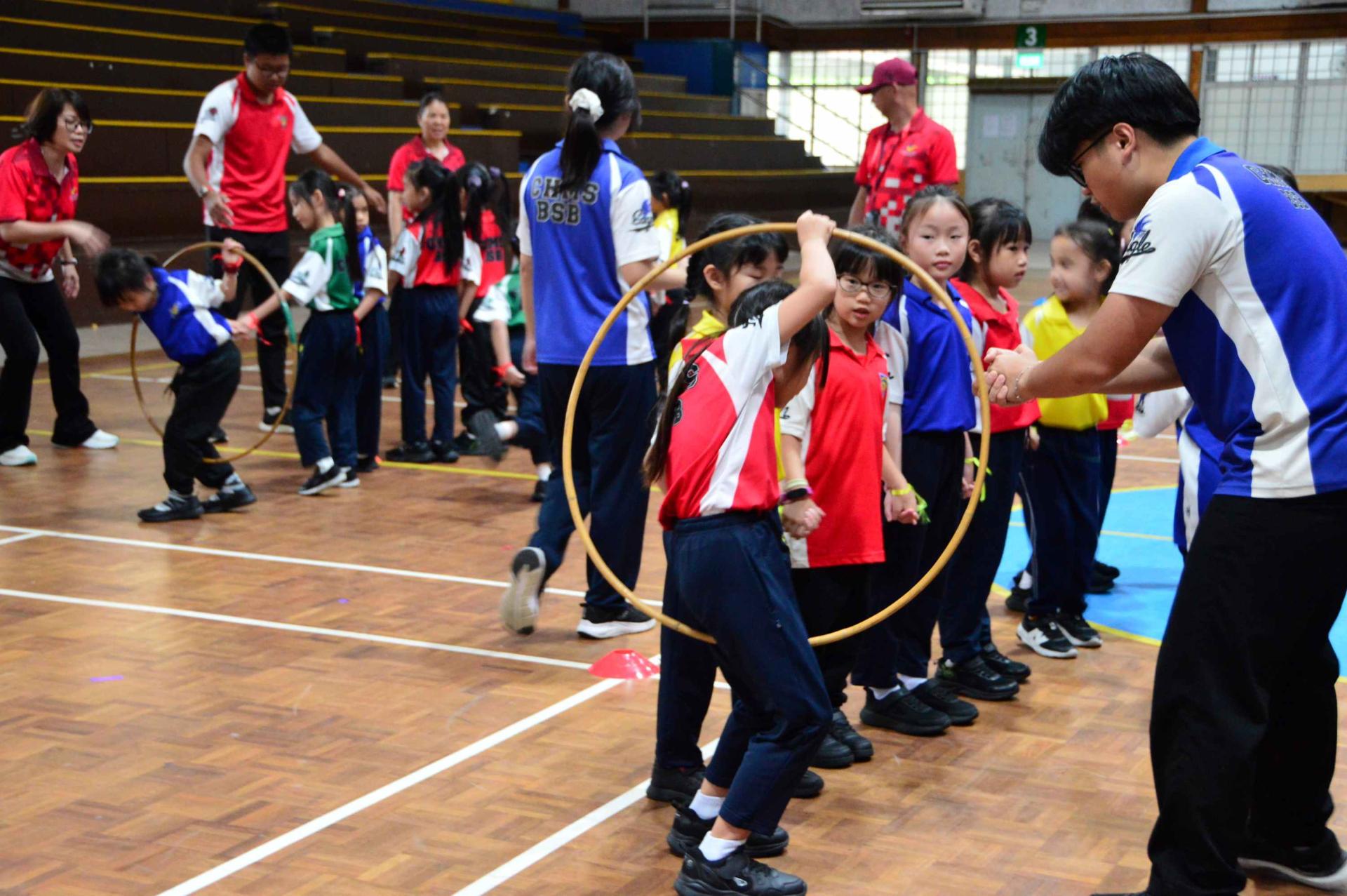 汶中小学生钻“呼啦圈”比赛。
